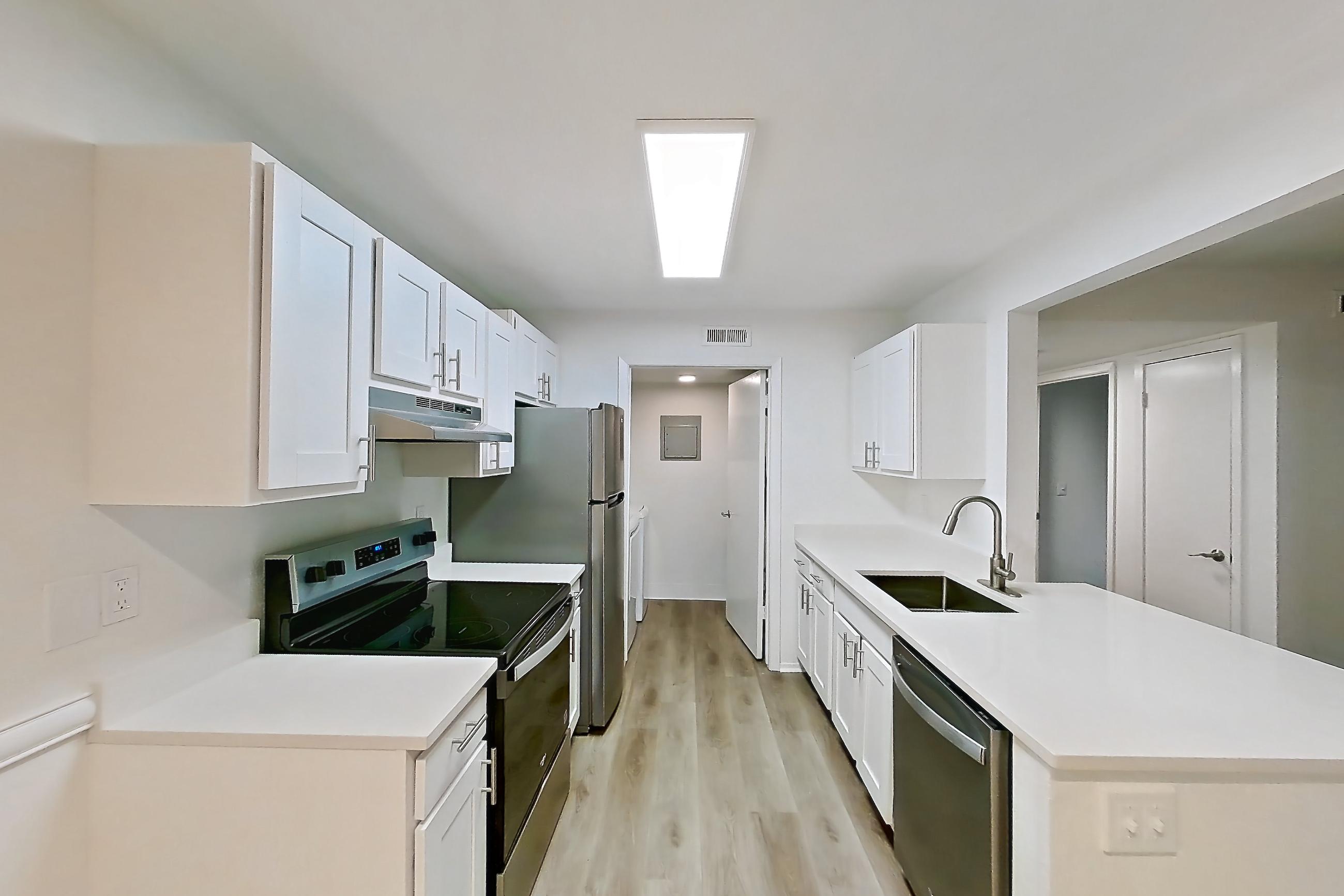 Dining room with dishwasher, electric range, light countertops, light wood-finish flooring, oven/range, refrigerator, and stainless steel appliances, Apartment 08S at James Pointe