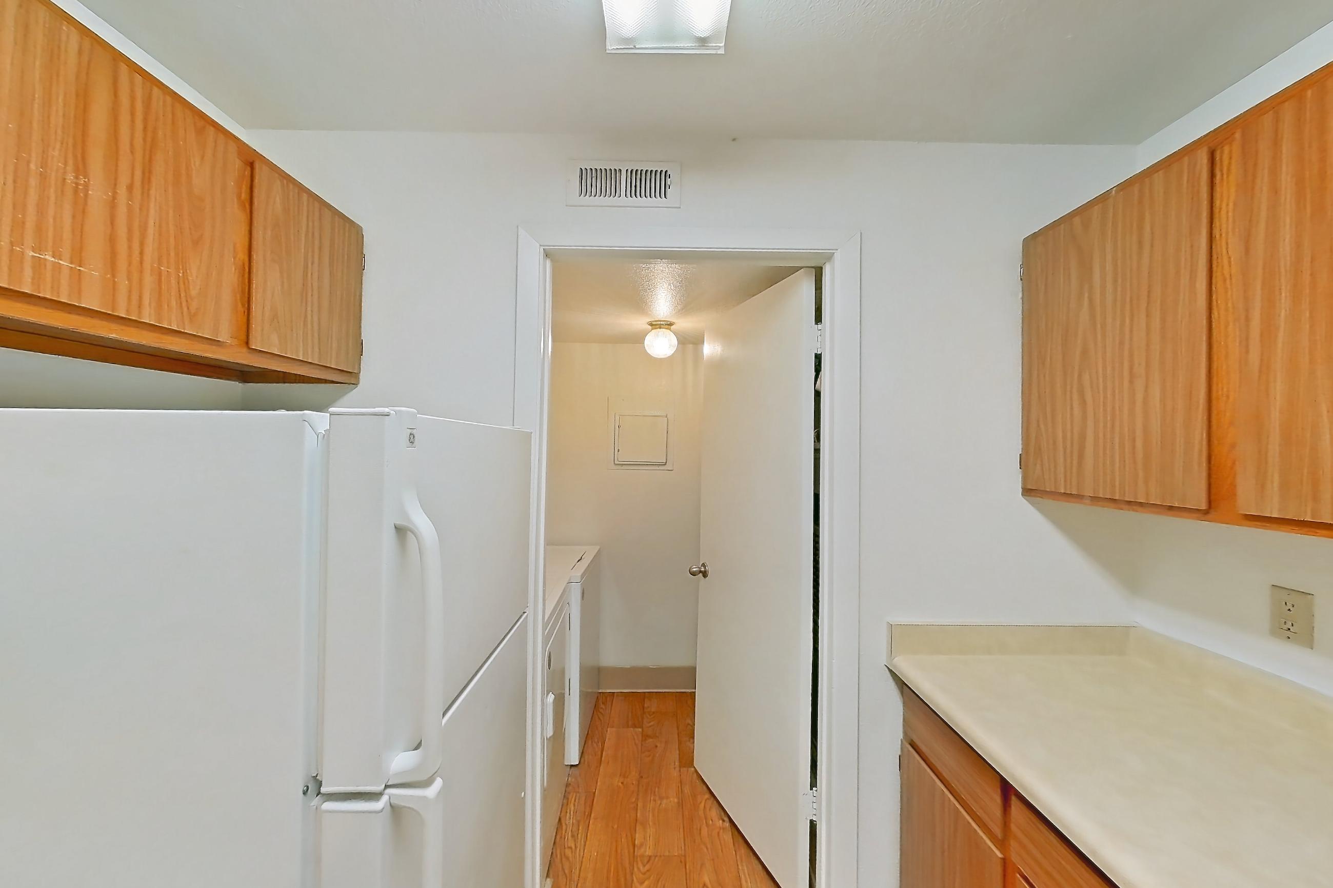 Kitchen with dishwasher, electric range, light countertops, light wood-finish flooring, oven/range, refrigerator, and white appliances, Apartment 12U at James Pointe