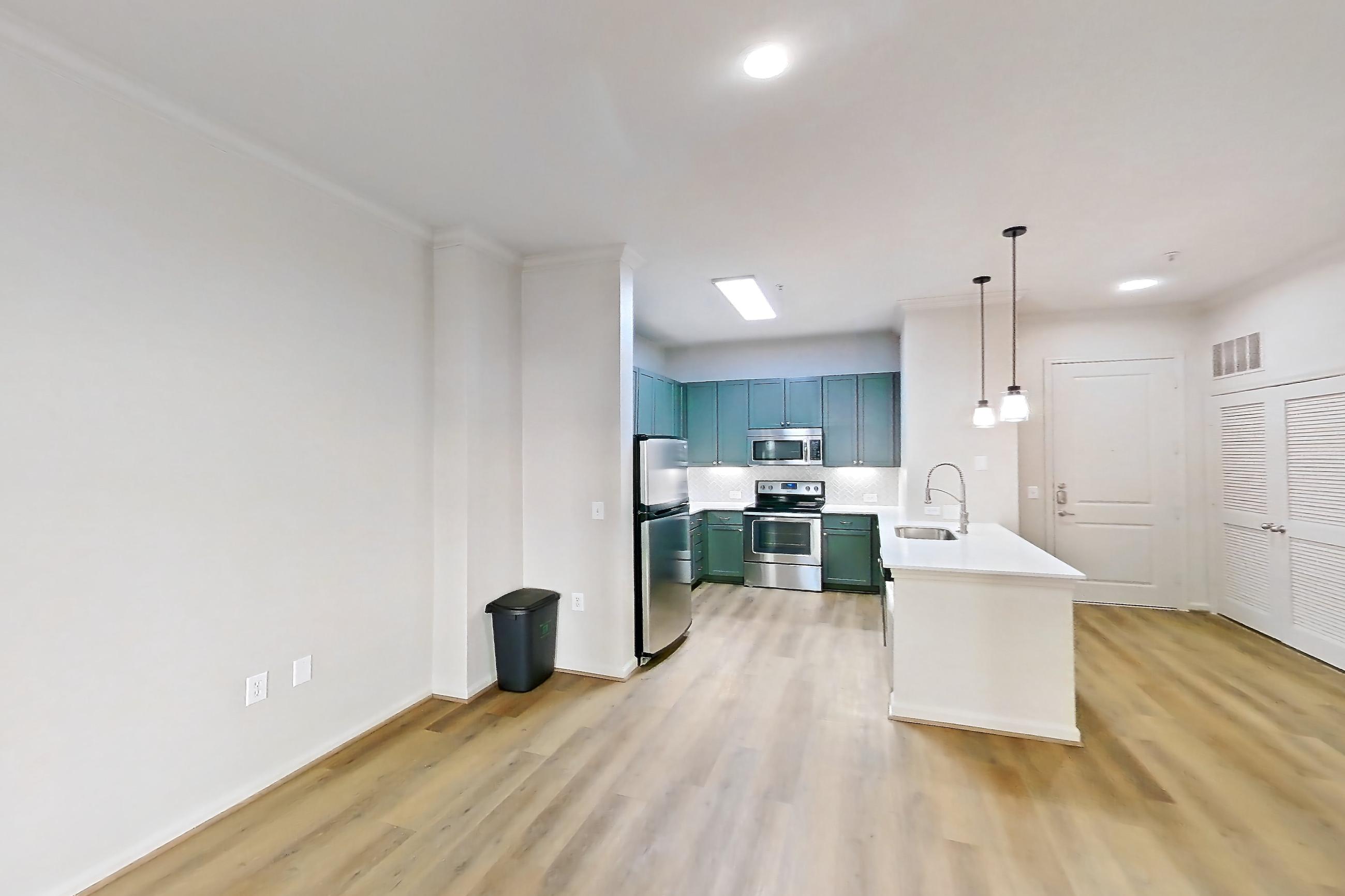 Living room with electric range, light stone countertops, light wood-finish flooring, oven/range, refrigerator, and stainless steel appliances, Apartment 1015 at La Maison at River Oaks