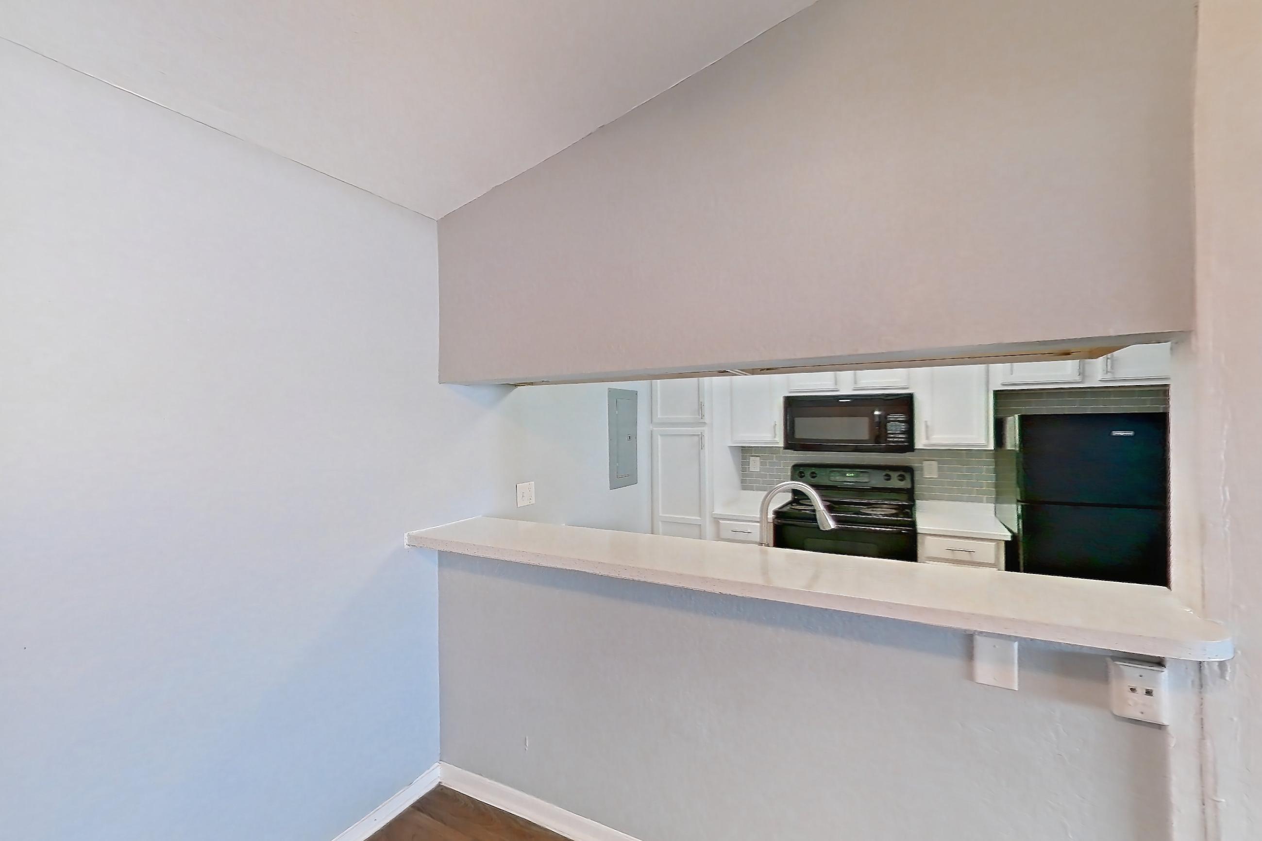 Dining room with black appliances, dark wood-finish flooring, electric range, fireplace, light countertops, oven/range, and refrigerator, Apartment 190 at Eleven600 Apartments