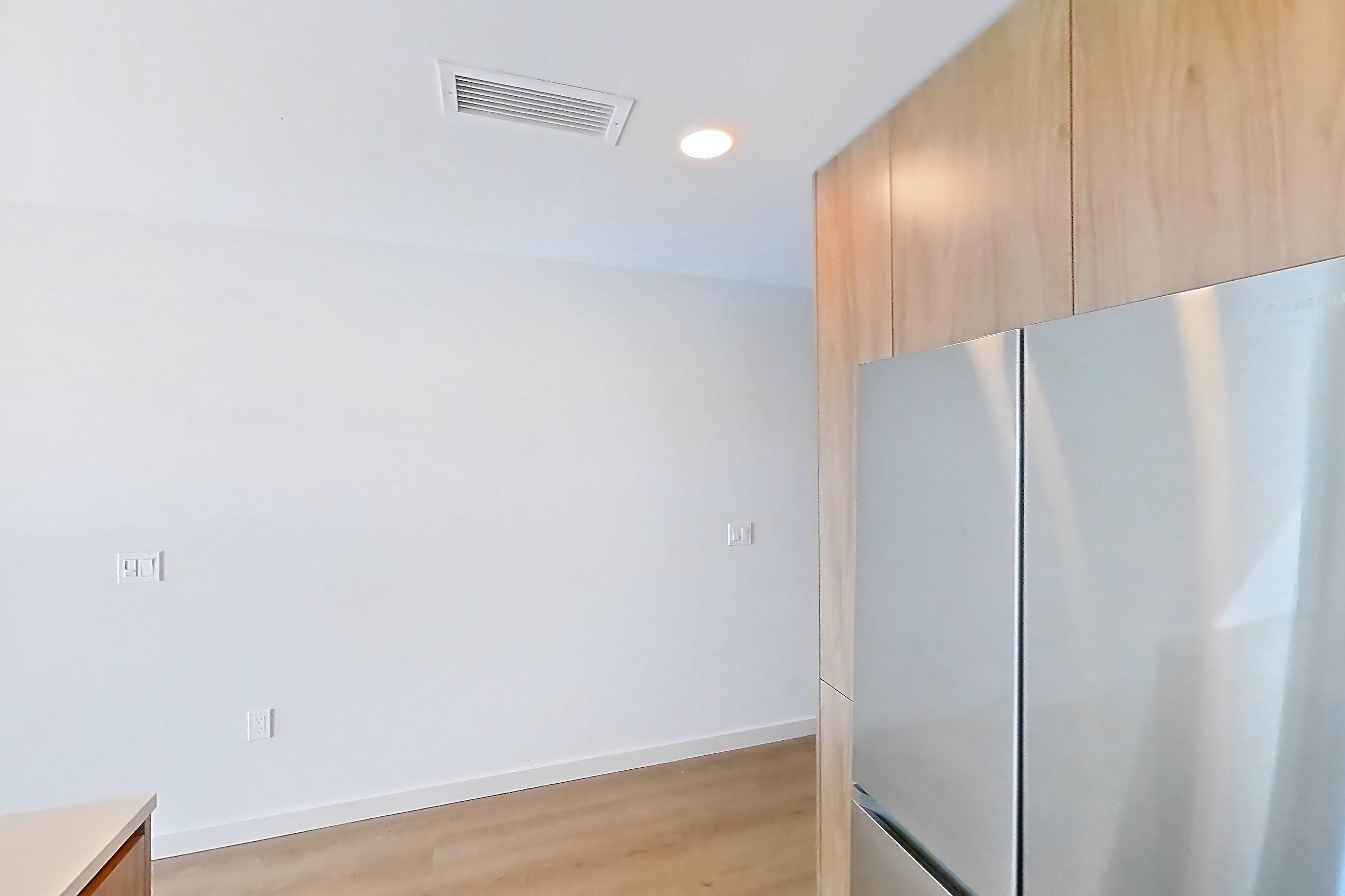Kitchen with dishwasher, electric range, light countertops, light stone countertops, light wood-finish flooring, microwave, oven/range, refrigerator, and stainless steel appliances, Apartment 410 at Rowyn