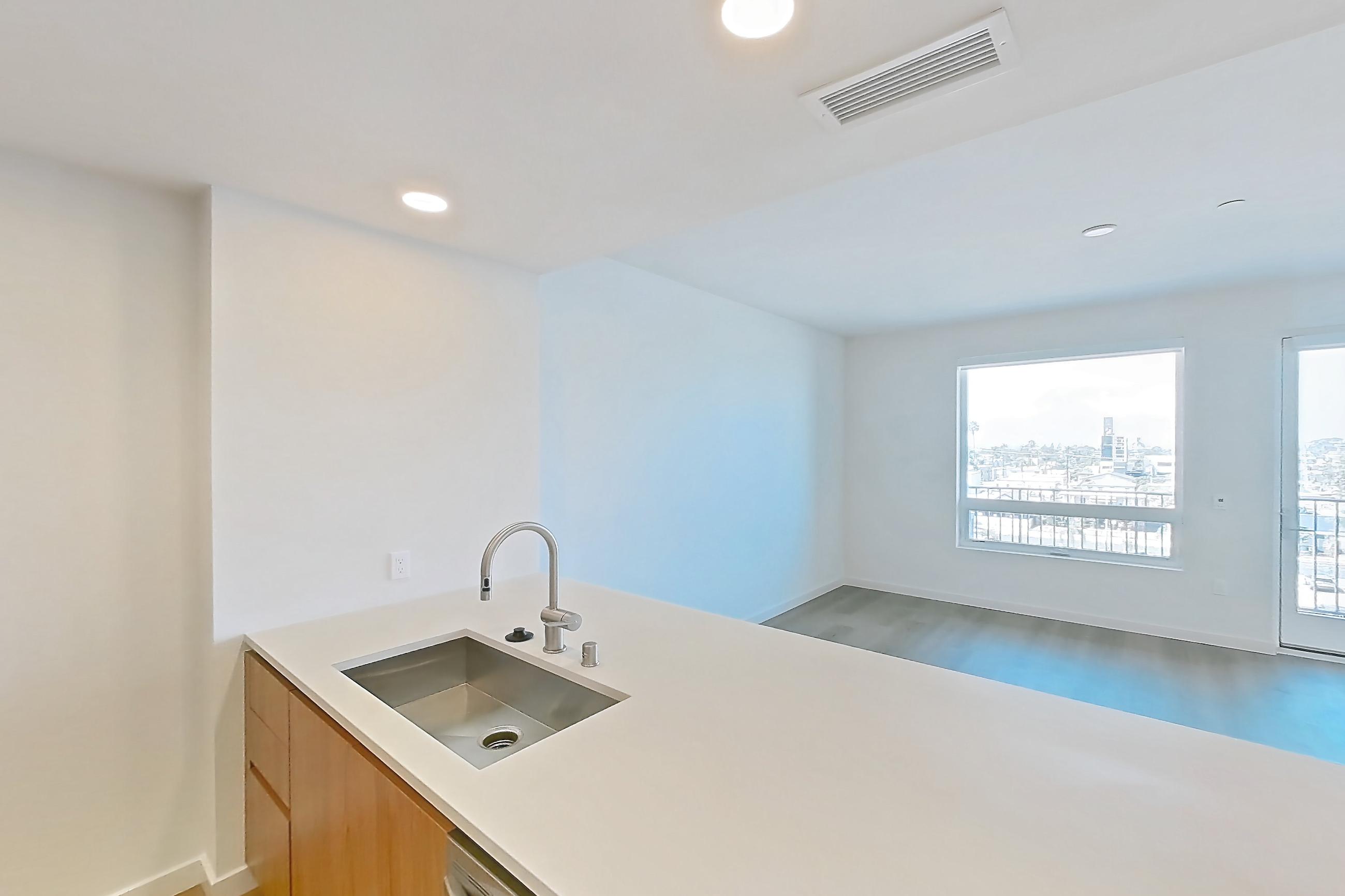 Kitchen with dishwasher, electric range, light countertops, light wood-finish flooring, microwave, oven/range, refrigerator, and stainless steel appliances, Apartment 610 at Rowyn