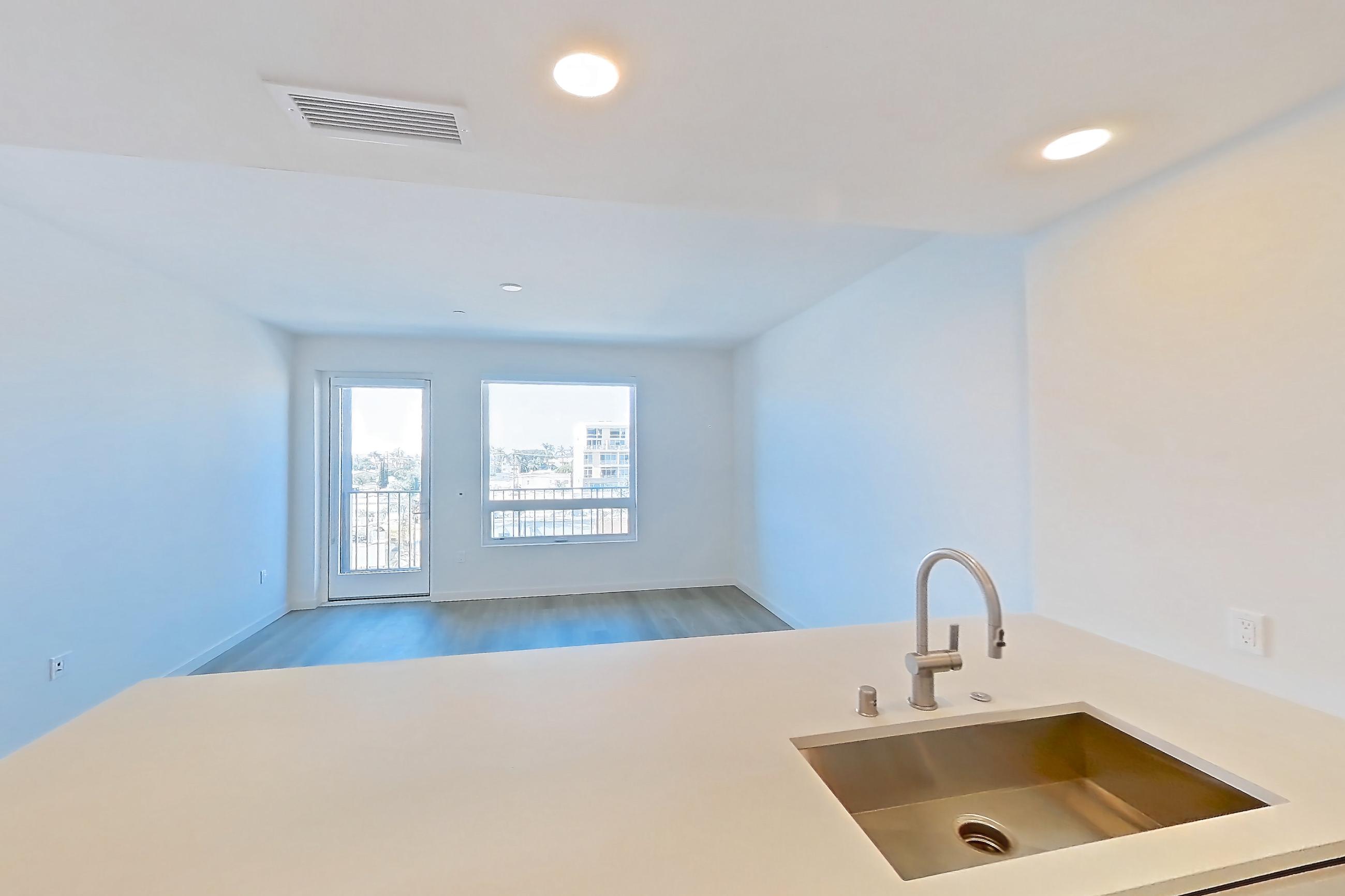 Kitchen with dishwasher, electric range, light countertops, light wood-finish flooring, microwave, oven/range, refrigerator, and stainless steel appliances, Apartment 546 at Rowyn