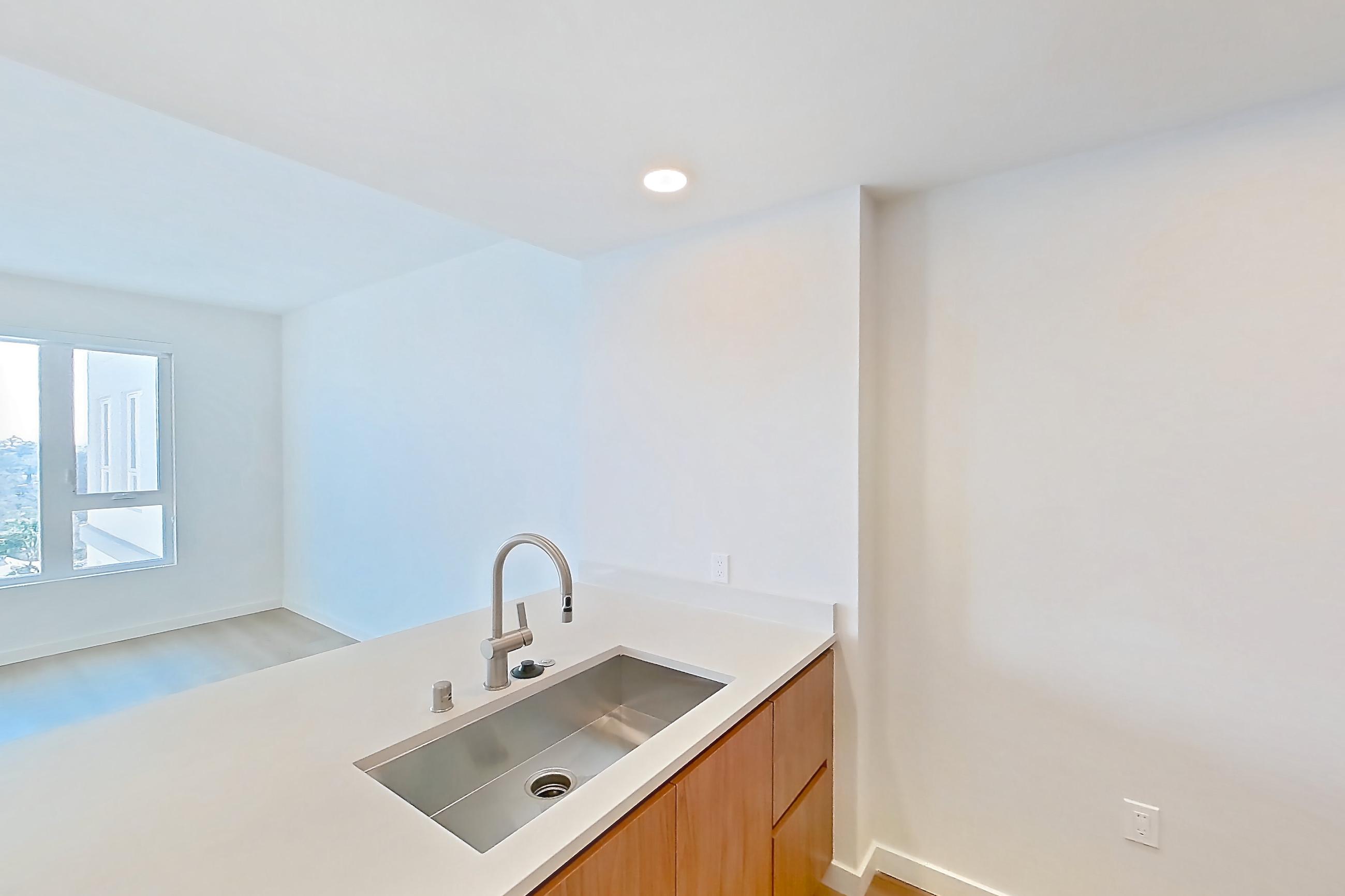Kitchen with dishwasher, electric range, light countertops, light wood-finish flooring, microwave, oven/range, refrigerator, and stainless steel appliances, Apartment 857 at Rowyn