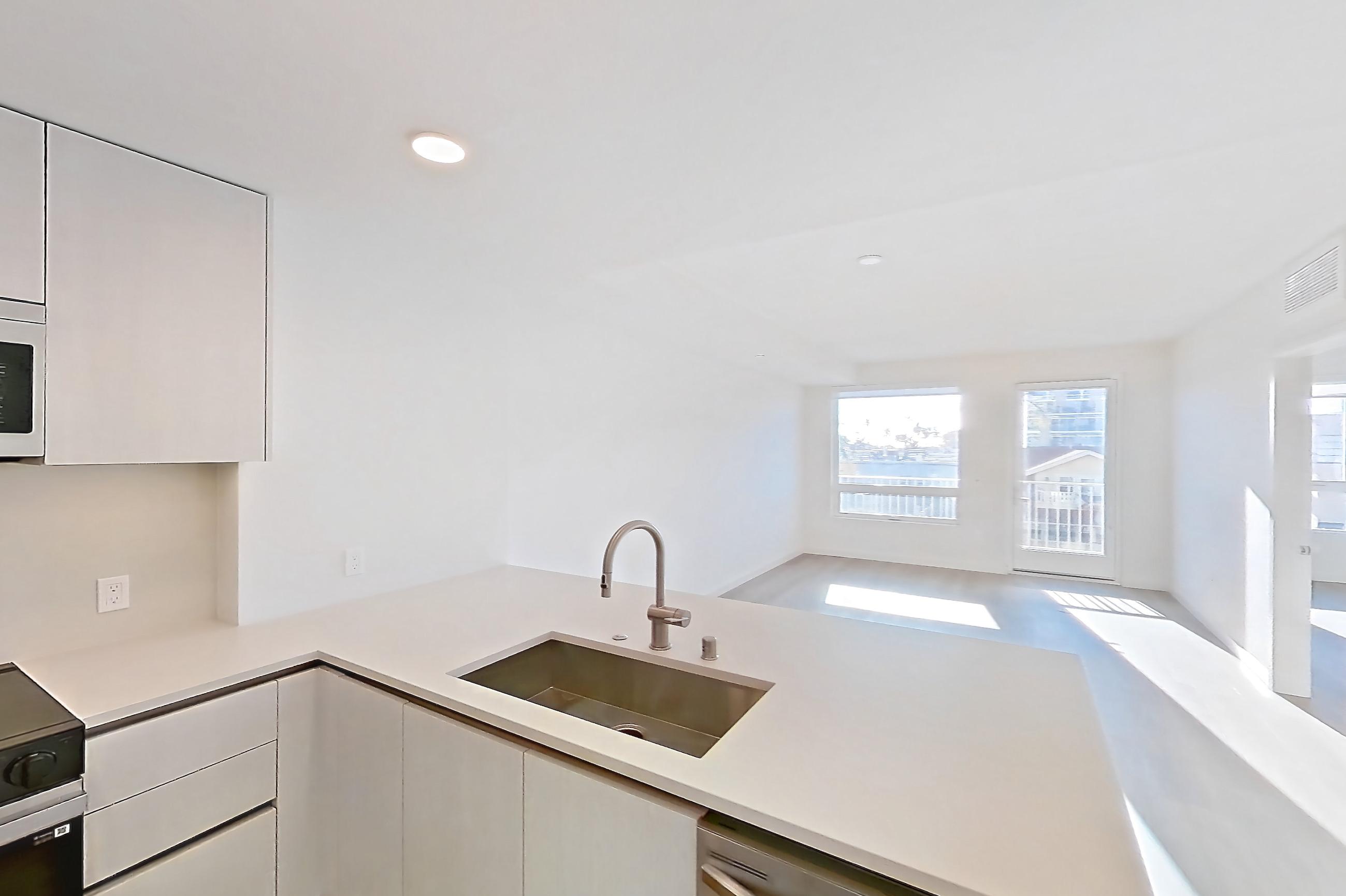 Kitchen with dishwasher, electric range, light countertops, light stone countertops, light wood-finish flooring, microwave, oven/range, refrigerator, and stainless steel appliances, Apartment 344 at Rowyn