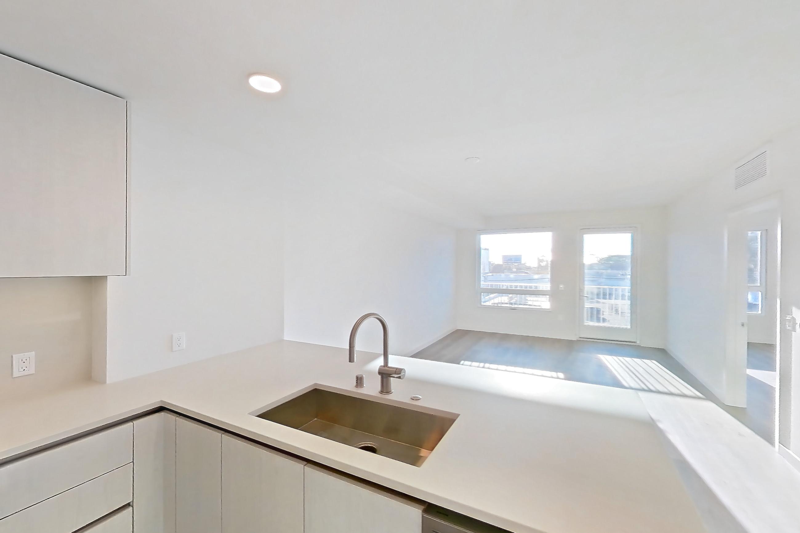 Kitchen with dishwasher, electric range, light countertops, light stone countertops, light wood-finish flooring, microwave, oven/range, refrigerator, and stainless steel appliances, Apartment 356 at Rowyn