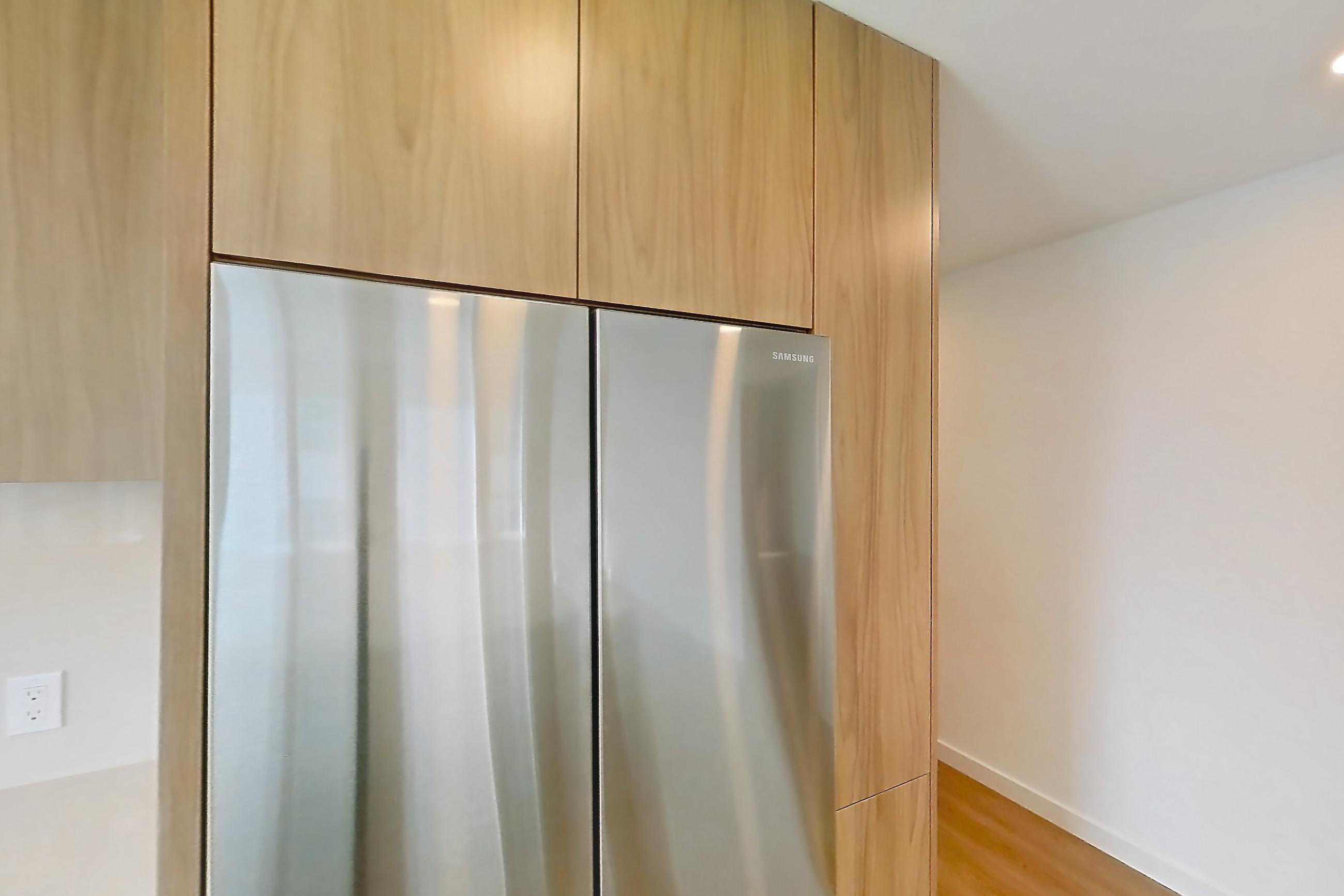 Kitchen with dishwasher, electric range, light countertops, light stone countertops, light wood-finish flooring, oven/range, refrigerator, and stainless steel appliances, Apartment 601 at Rowyn