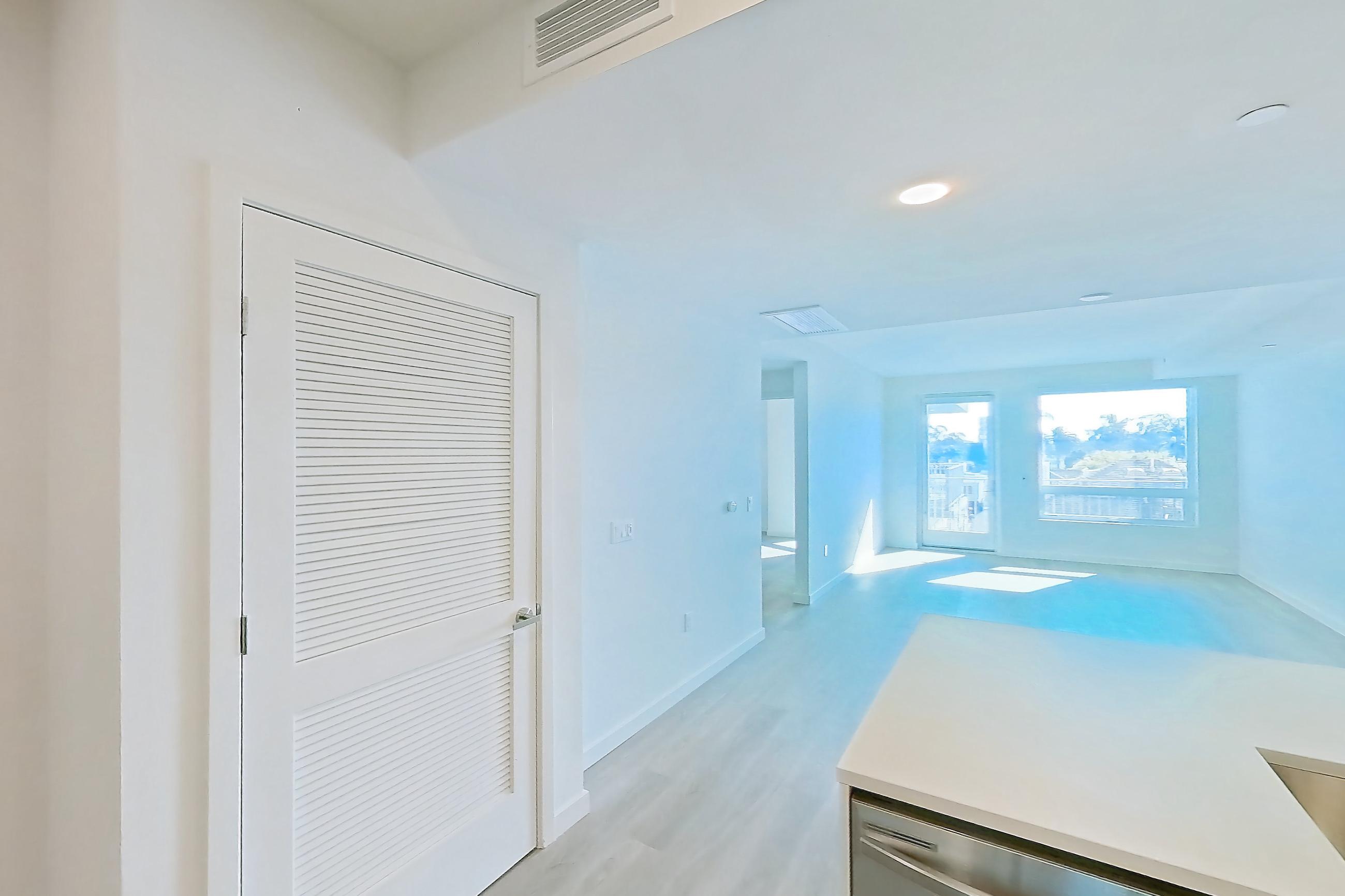 Kitchen with dishwasher, electric range, light countertops, light stone countertops, light wood-finish flooring, microwave, oven/range, refrigerator, and stainless steel appliances, Apartment 339 at Rowyn