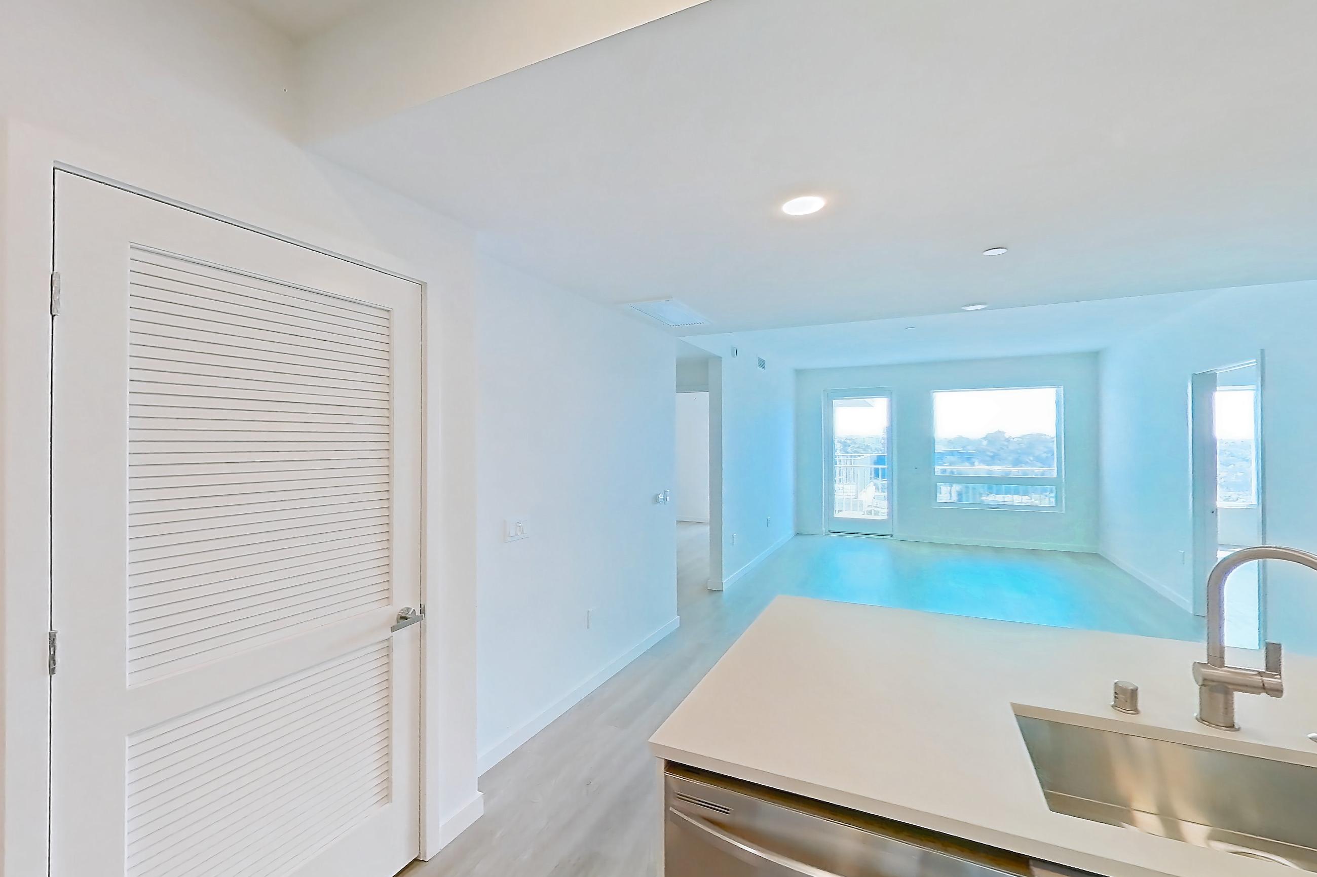 Kitchen with dishwasher, electric range, light countertops, light wood-finish flooring, microwave, oven/range, refrigerator, and stainless steel appliances, Apartment 739 at Rowyn