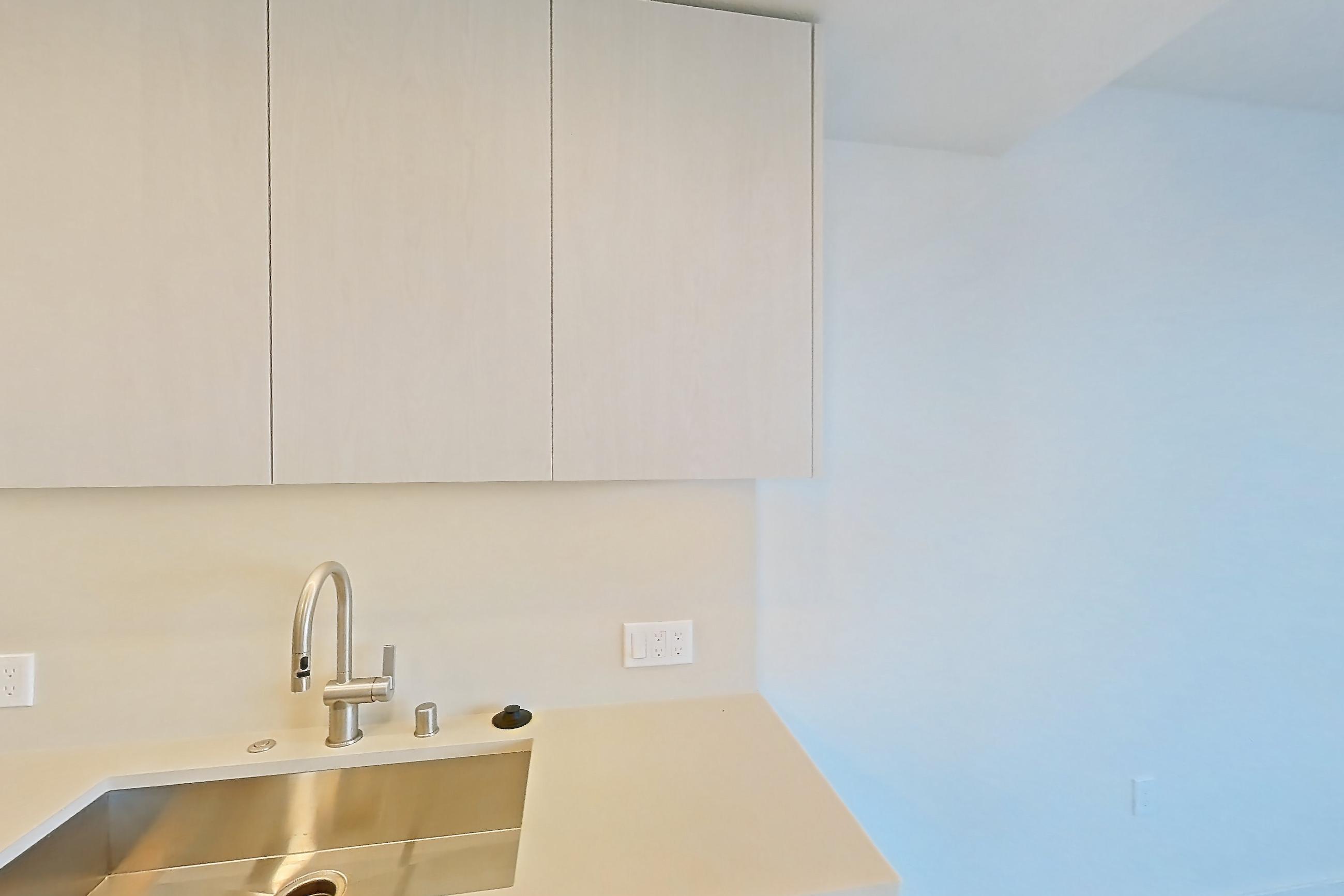 Kitchen with dishwasher, electric range, light countertops, light wood-finish flooring, microwave, oven/range, refrigerator, and stainless steel appliances, Apartment 325 at Rowyn