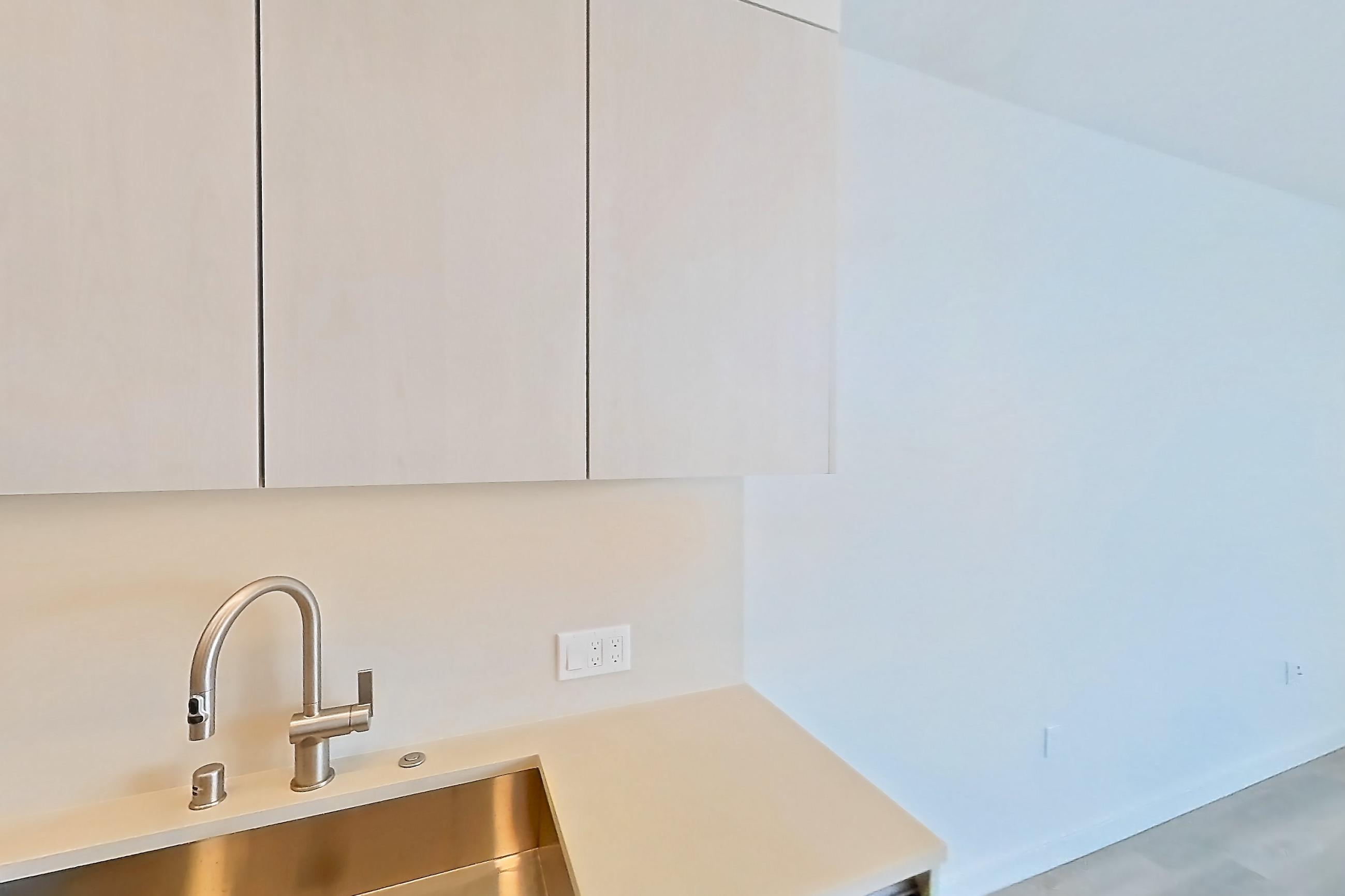 Kitchen with dishwasher, electric range, light countertops, light wood-finish flooring, microwave, oven/range, refrigerator, and stainless steel appliances, Apartment 525 at Rowyn