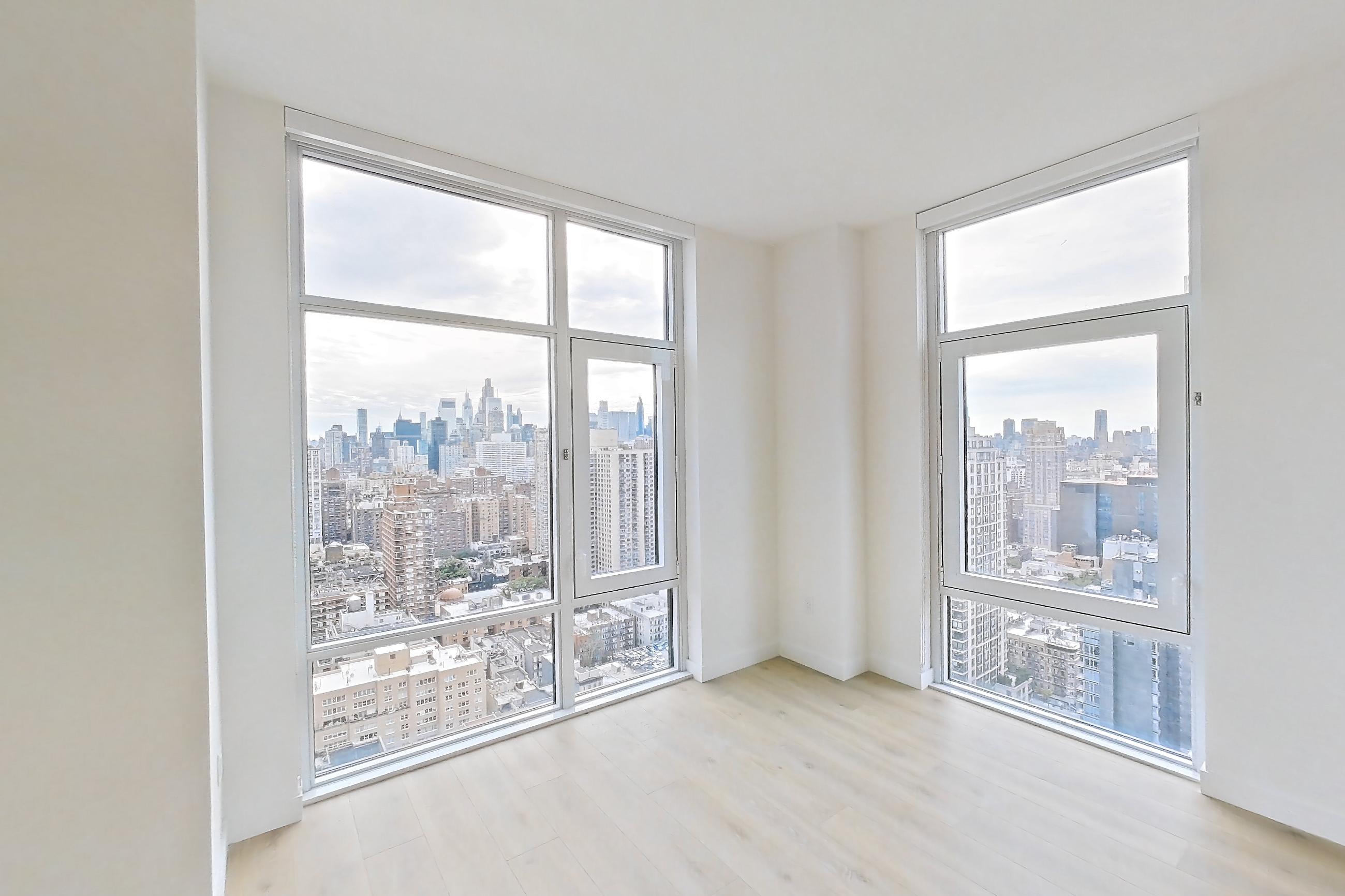 Living room with city view, cooktop, gas cooktop, light wood-finish flooring, oven/range, skyline view, and stainless steel appliances, Apartment 31C at Maison 78