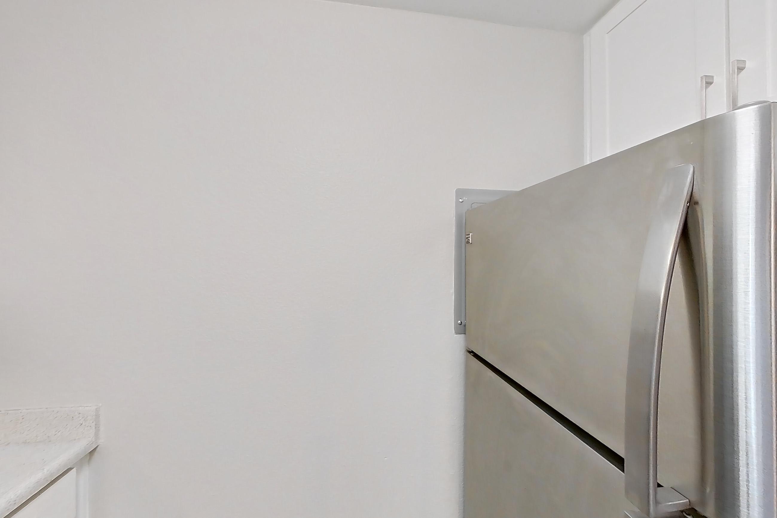 Kitchen with dishwasher, electric range, light countertops, light stone countertops, light wood-finish flooring, oven/range, range hood, refrigerator, and stainless steel appliances, Apartment 06-08 at Avana Rancho Cucamonga