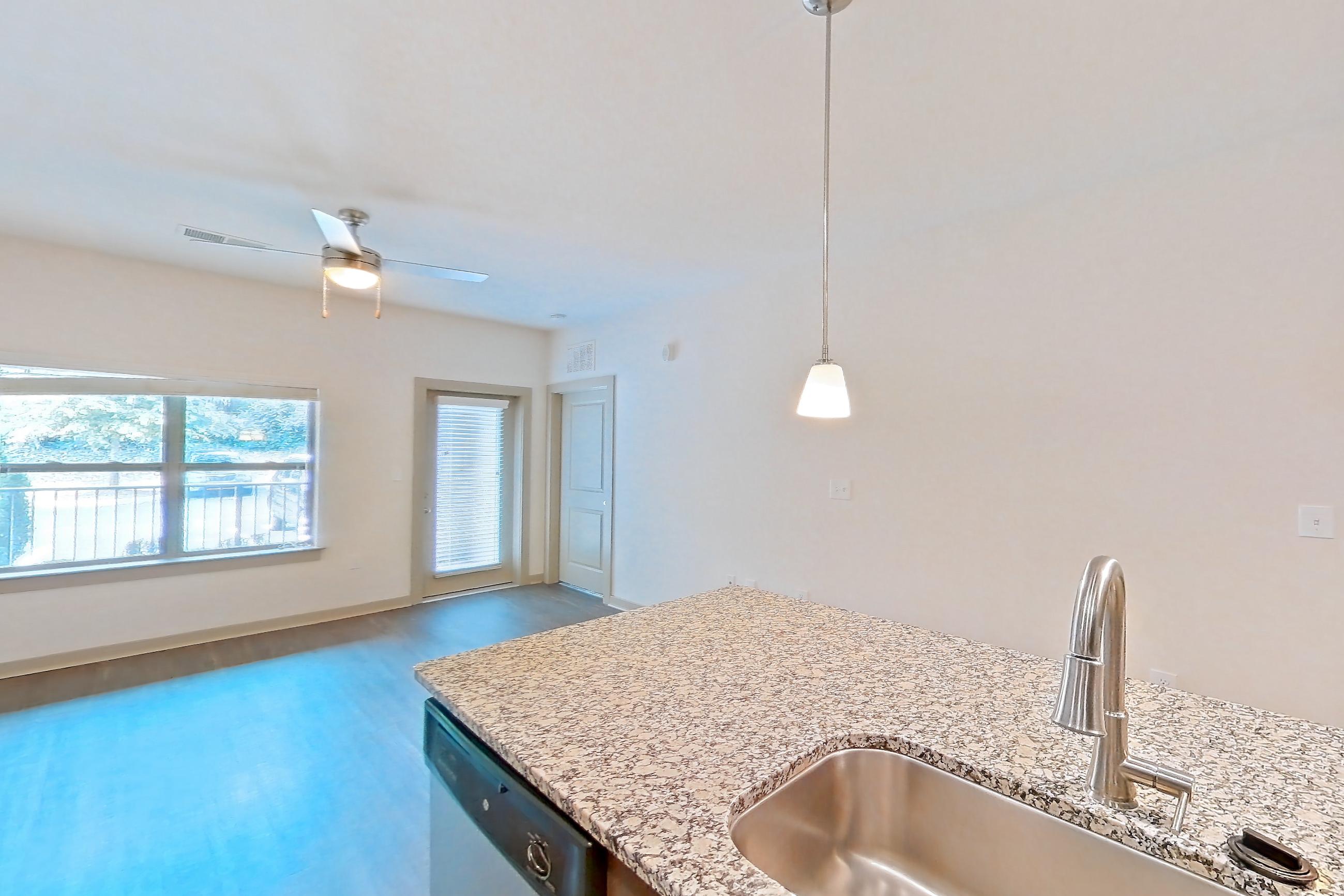 Kitchen with dishwasher, electric range, light stone countertops, light wood-finish flooring, microwave, oven/range, refrigerator, stainless steel appliances, and water & ice dispenser, Apartment 7-206 at Aventine Northshore