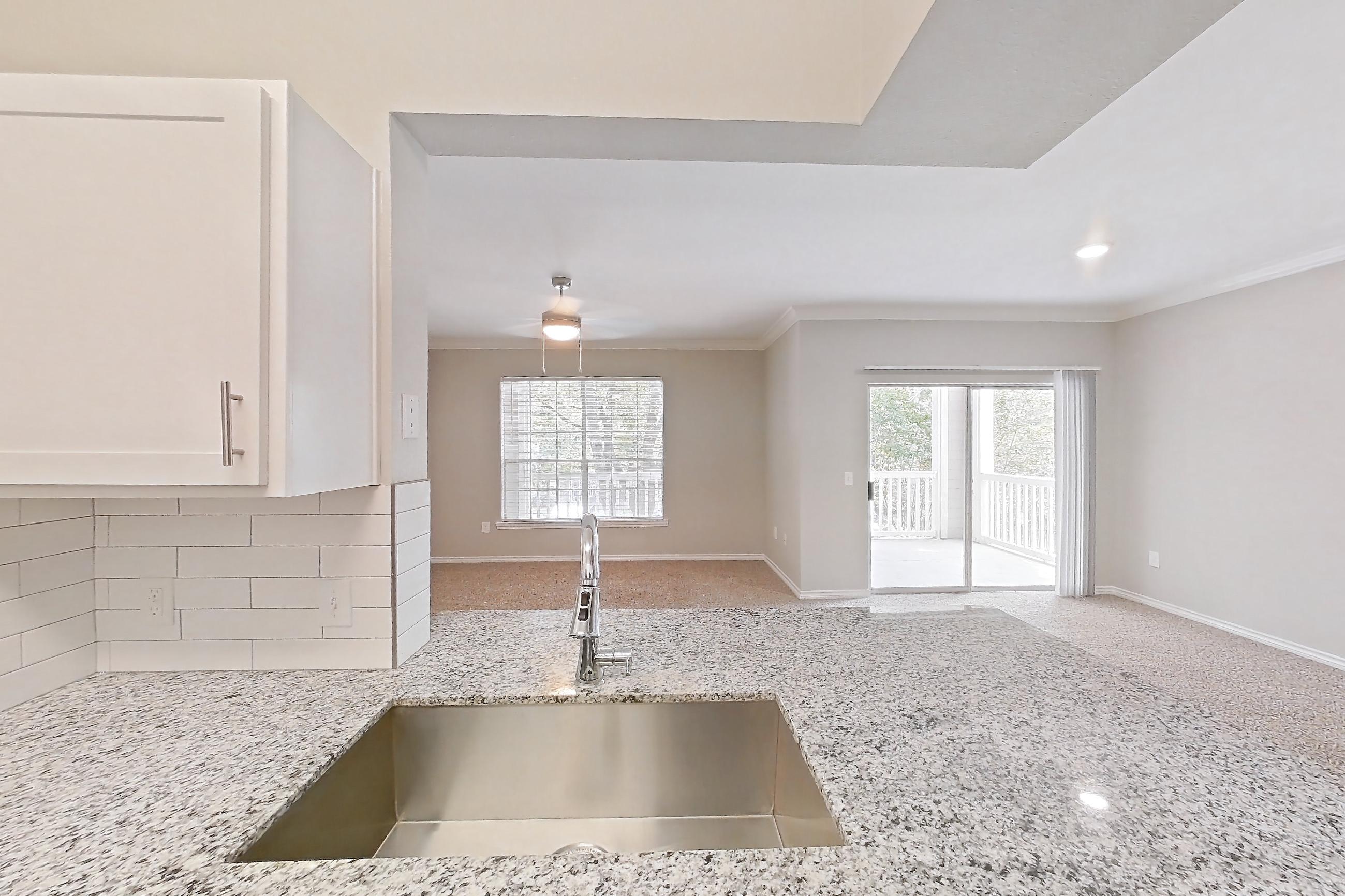 Kitchen with dark wood-finish flooring, dishwasher, electric range, light countertops, light stone countertops, oven/range, refrigerator, and stainless steel appliances, Apartment 0722 at Reserve at Kingwood
