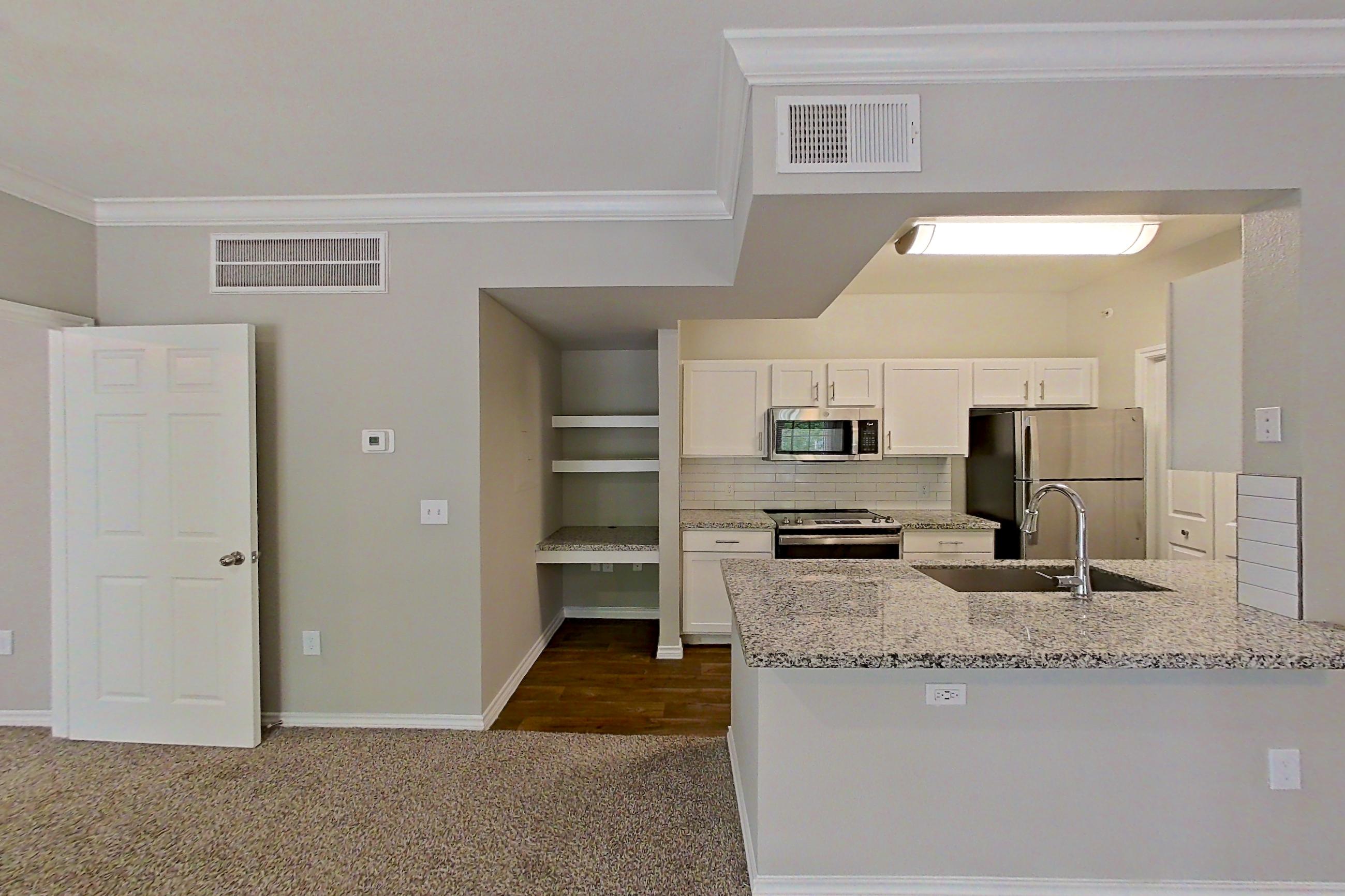 Living room with dark carpet, electric range, kitchen island, light stone countertops, oven/range, refrigerator, and stainless steel appliances, Apartment 0722 at Reserve at Kingwood
