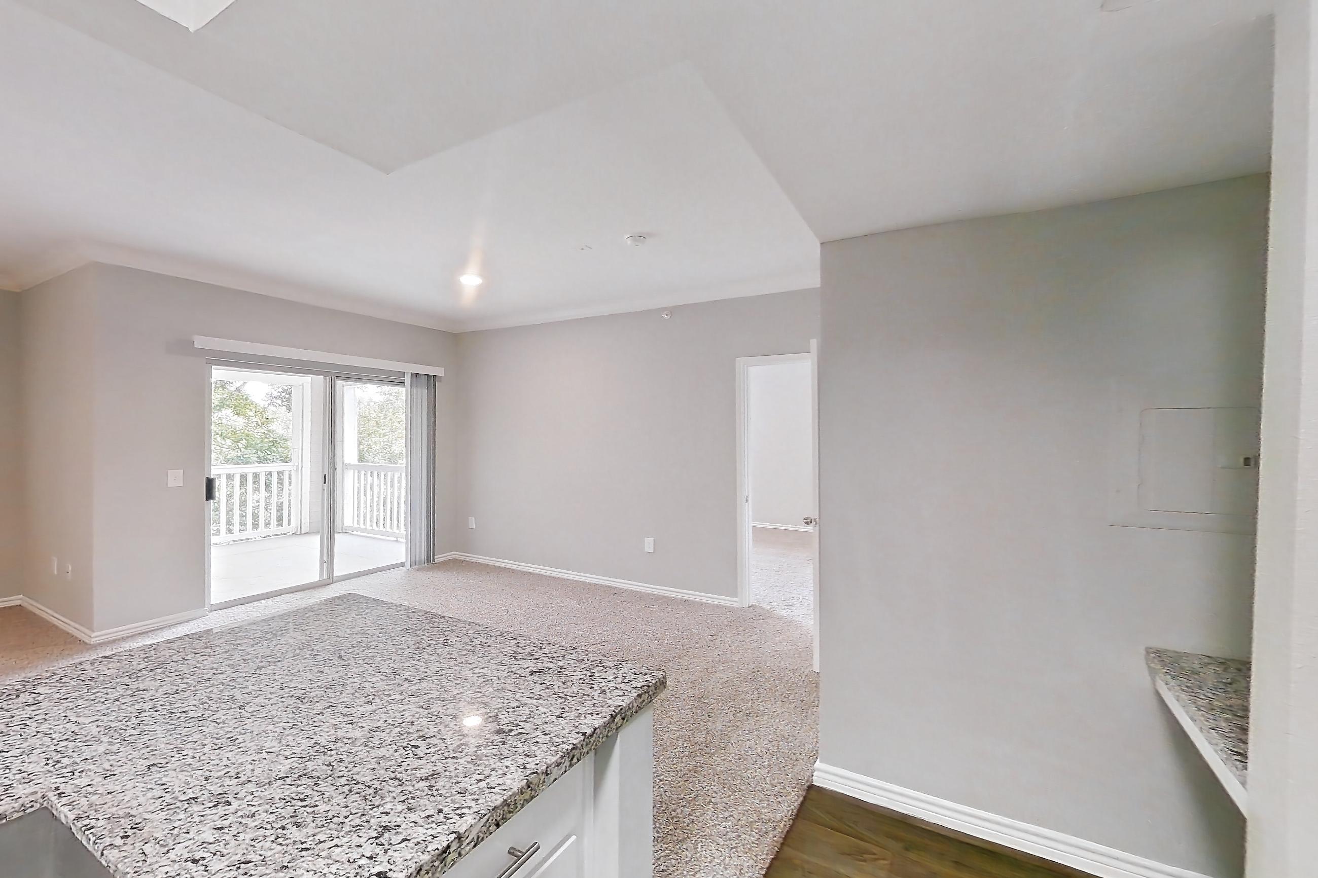 Kitchen with dark carpet, dark wood-finish flooring, dishwasher, electric range, light countertops, light stone countertops, oven/range, refrigerator, and stainless steel appliances, Apartment 0632 at Reserve at Kingwood