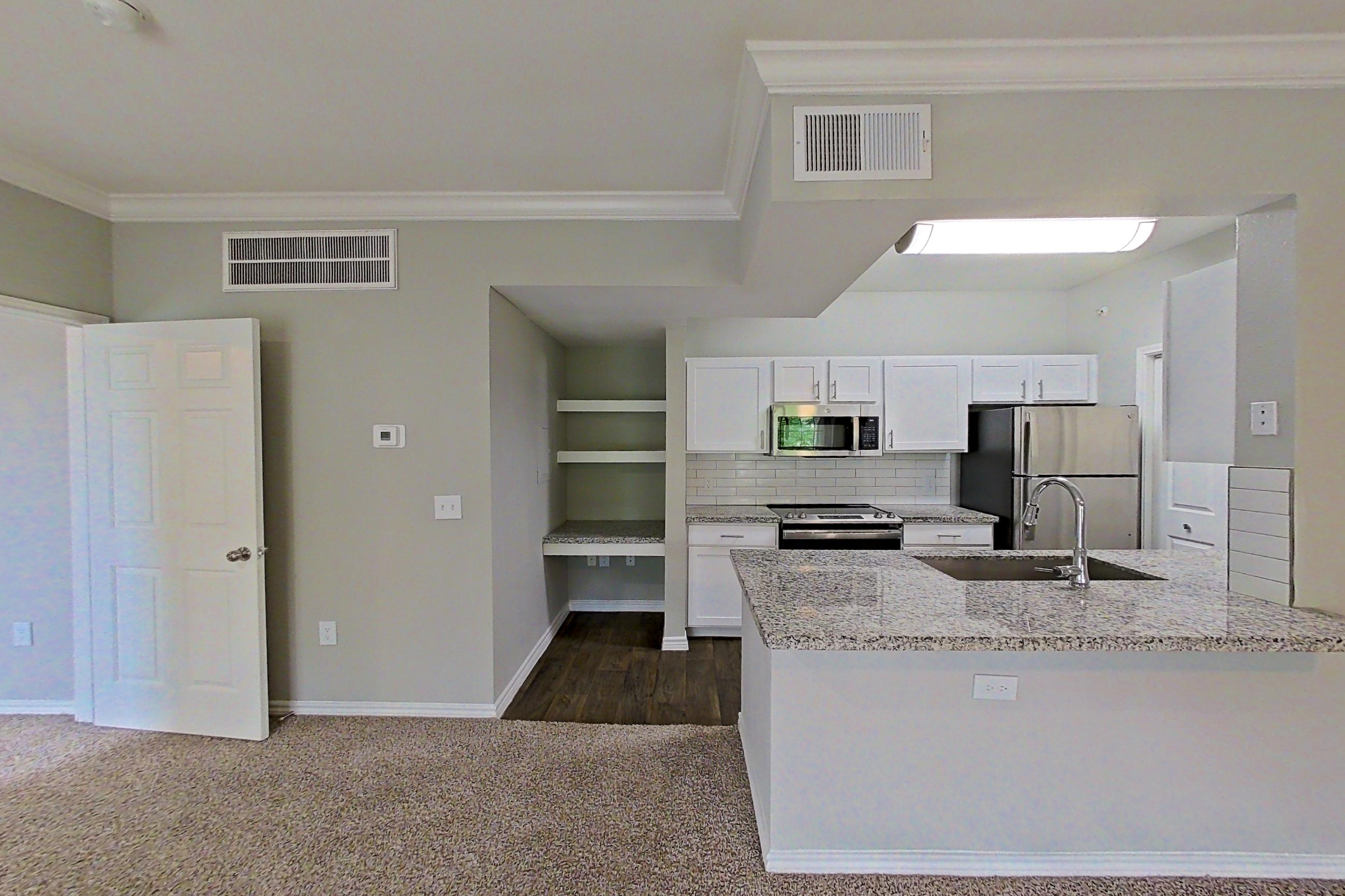 Living room with dark carpet, electric range, kitchen island, light stone countertops, oven/range, and stainless steel appliances, Apartment 0632 at Reserve at Kingwood