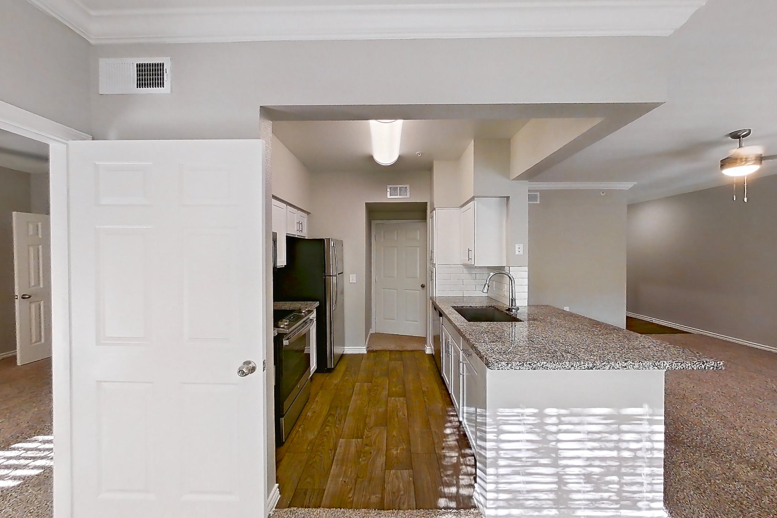 Dining room with dark carpet, dark wood-finish flooring, dishwasher, light stone countertops, oven/range, refrigerator, and stainless steel appliances, Apartment 0535 at Reserve at Kingwood