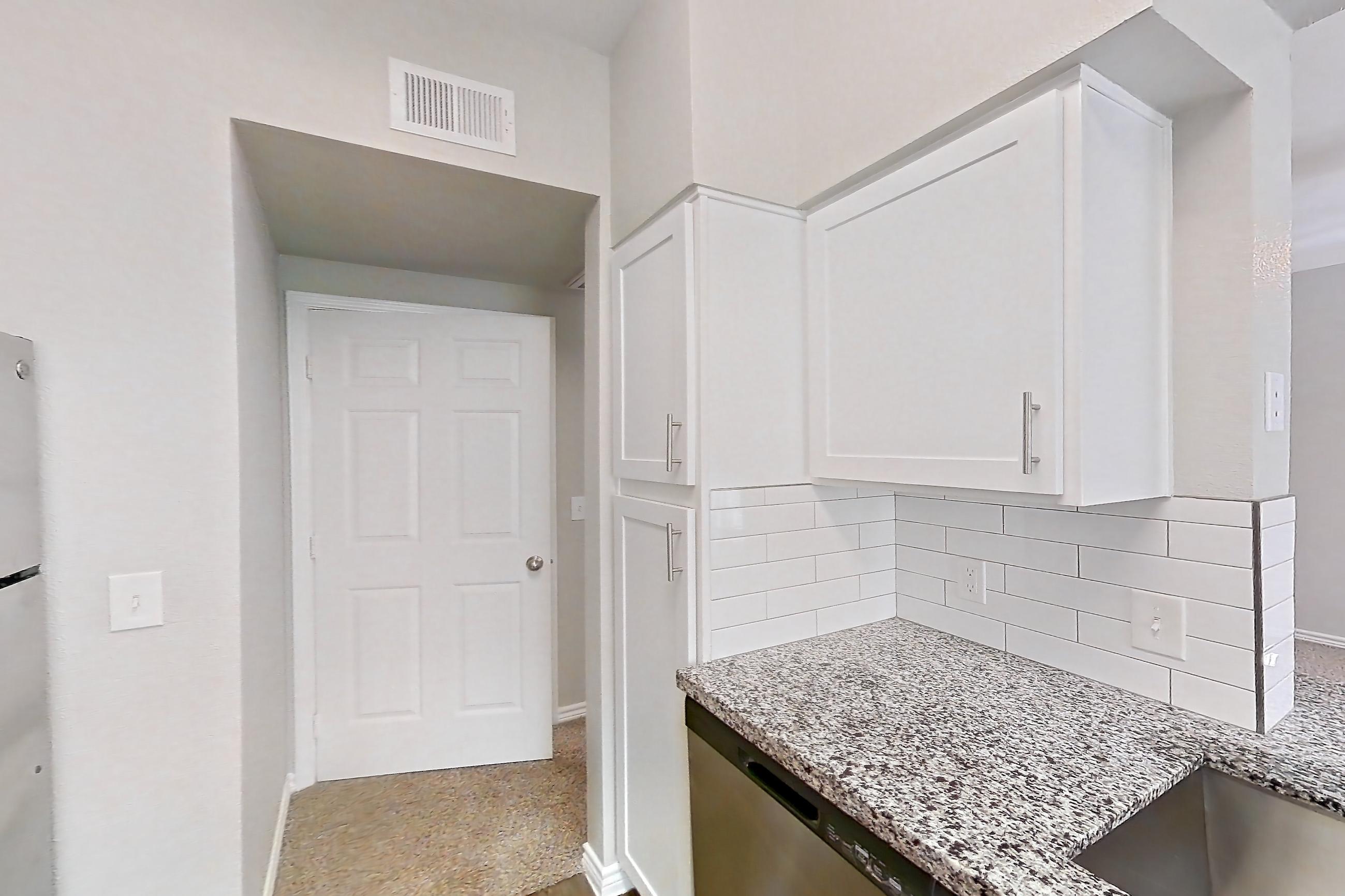 Kitchen with dark wood-finish flooring, dishwasher, electric range, light carpet, light countertops, light stone countertops, light wood-finish flooring, oven/range, refrigerator, and stainless steel appliances, Apartment 0535 at Reserve at Kingwood
