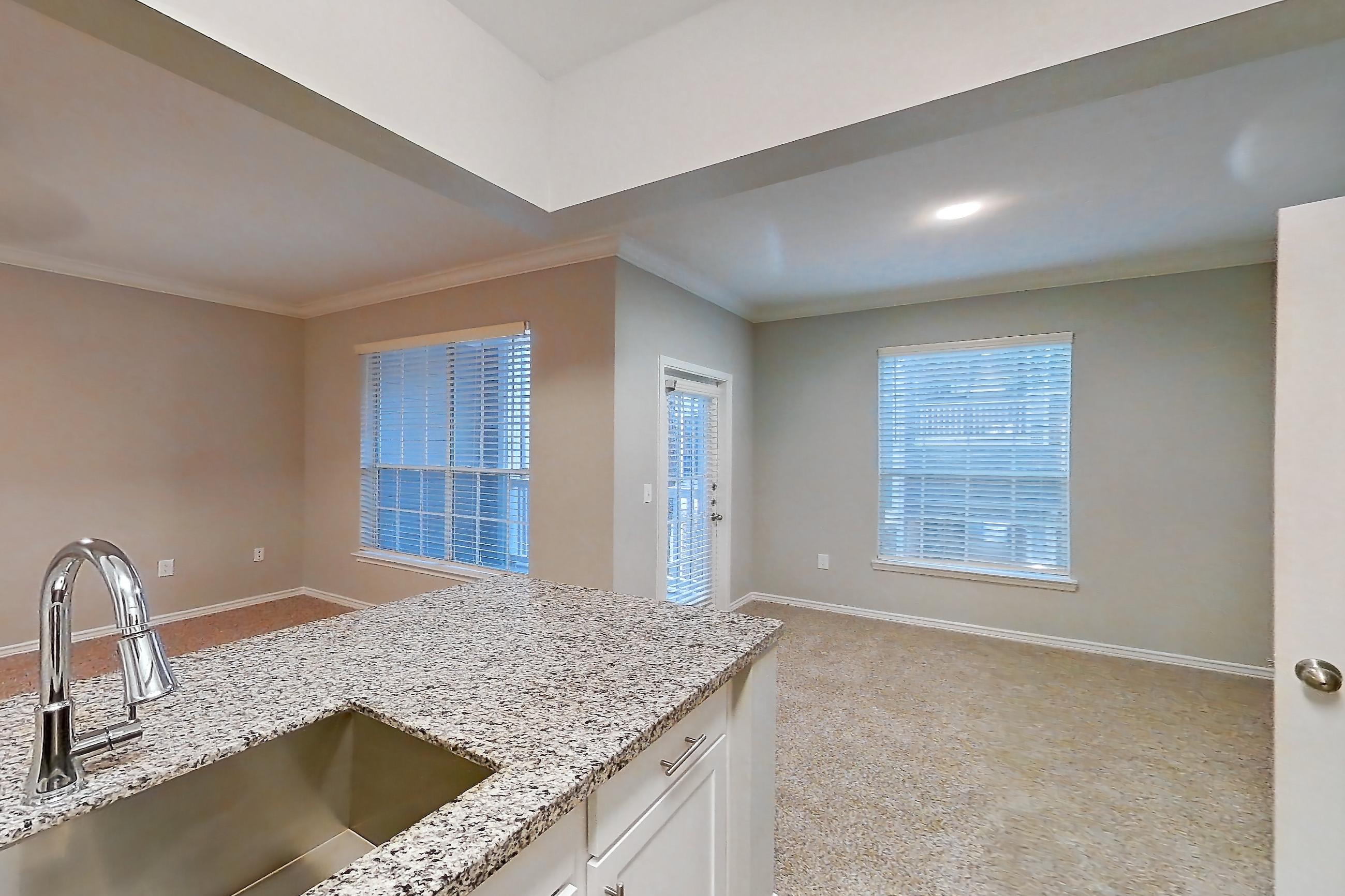 Kitchen with dark carpet, dark wood-finish flooring, dishwasher, electric range, light stone countertops, light wood-finish flooring, oven/range, refrigerator, and stainless steel appliances, Apartment 0920 at Reserve at Kingwood