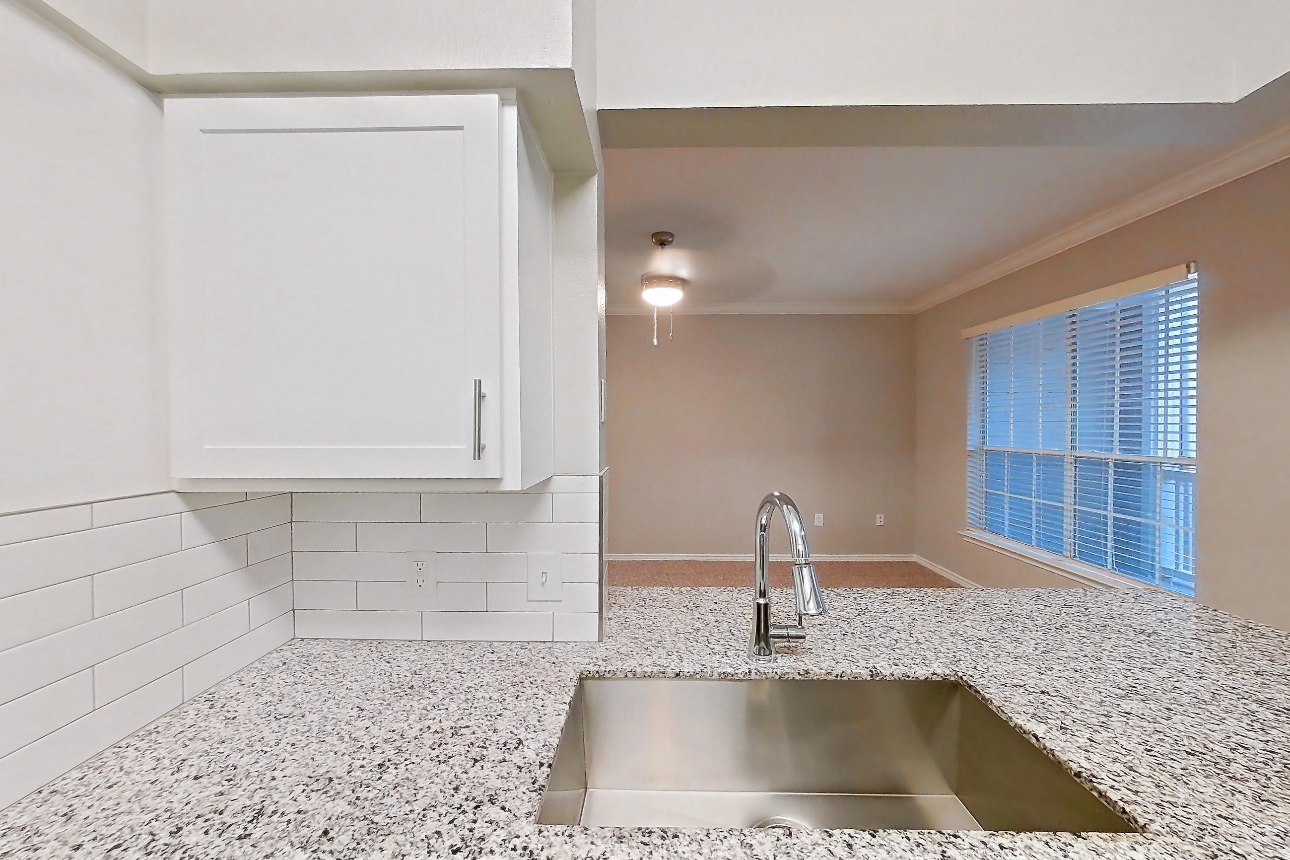 Kitchen with dark carpet, dark wood-finish flooring, dishwasher, electric range, light stone countertops, light wood-finish flooring, oven/range, refrigerator, and stainless steel appliances, Apartment 0920 at Reserve at Kingwood