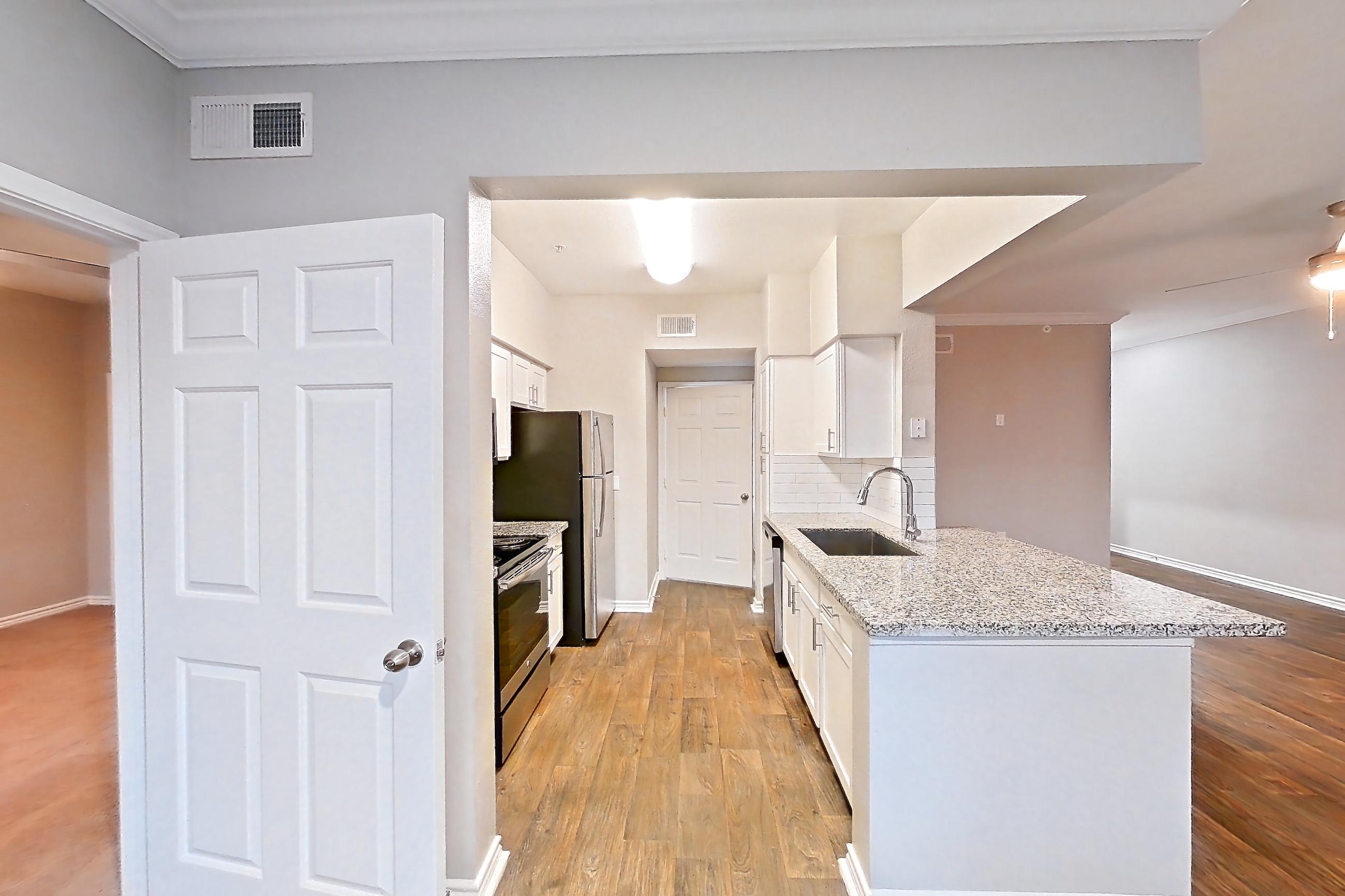 Dining room with dark wood-finish flooring, dishwasher, electric range, light stone countertops, oven/range, refrigerator, and stainless steel appliances, Apartment 1115 at Reserve at Kingwood