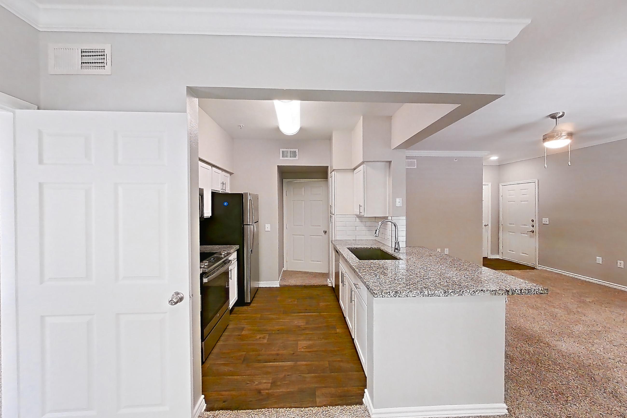 Dining room with dark carpet, electric range, light carpet, light stone countertops, oven/range, refrigerator, and stainless steel appliances, Apartment 1121 at Reserve at Kingwood