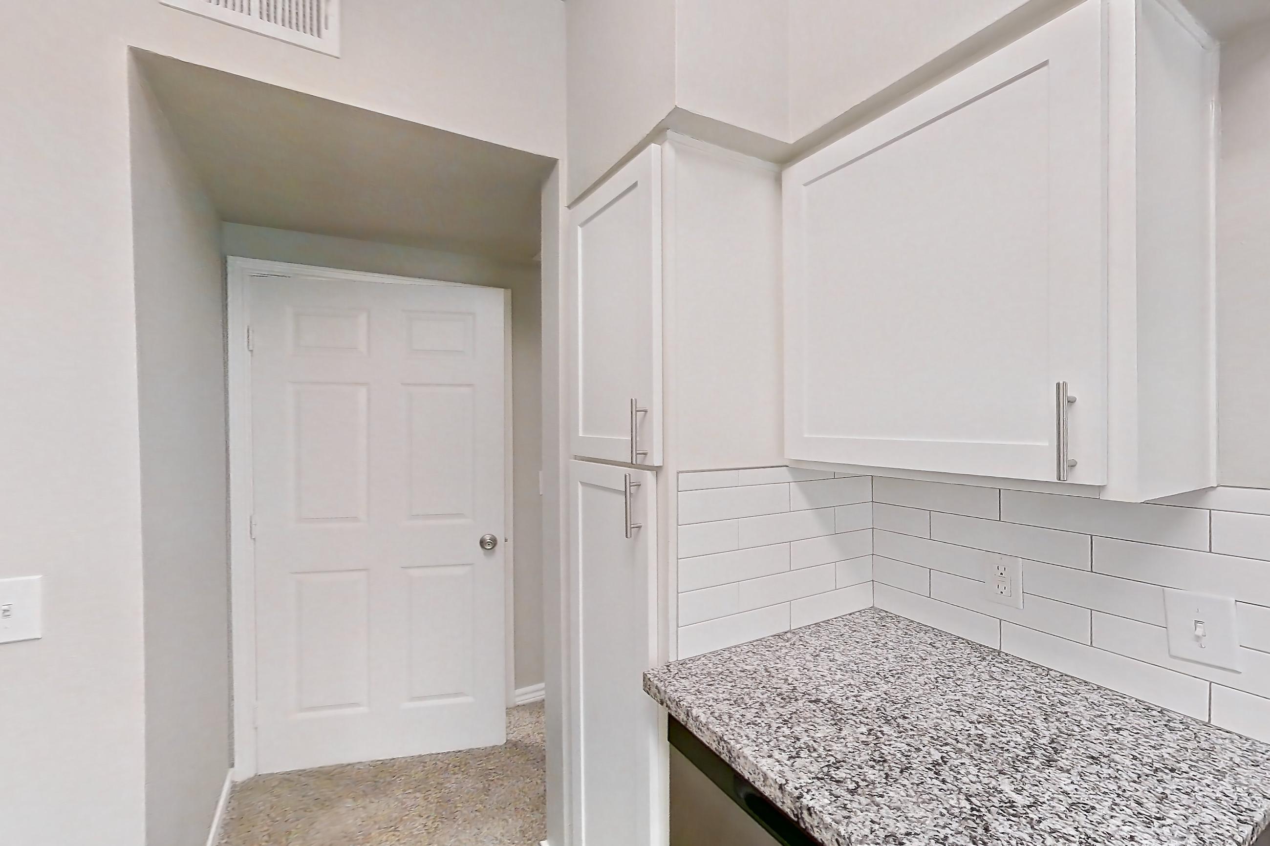 Kitchen with dark carpet, dark wood-finish flooring, dishwasher, electric range, light stone countertops, oven/range, refrigerator, and stainless steel appliances, Apartment 1121 at Reserve at Kingwood