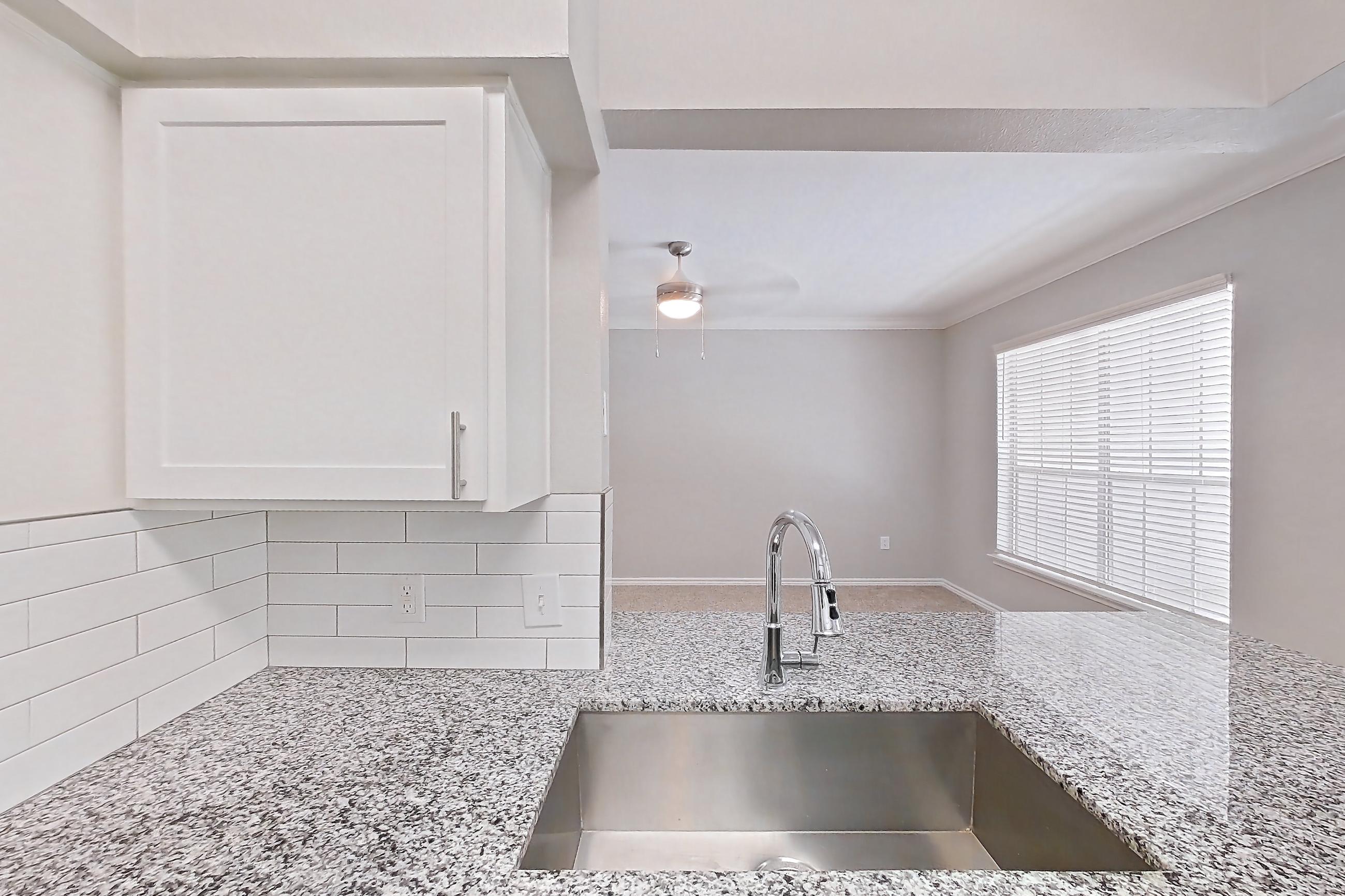 Kitchen with dark carpet, dark wood-finish flooring, dishwasher, electric range, light stone countertops, oven/range, refrigerator, and stainless steel appliances, Apartment 1121 at Reserve at Kingwood