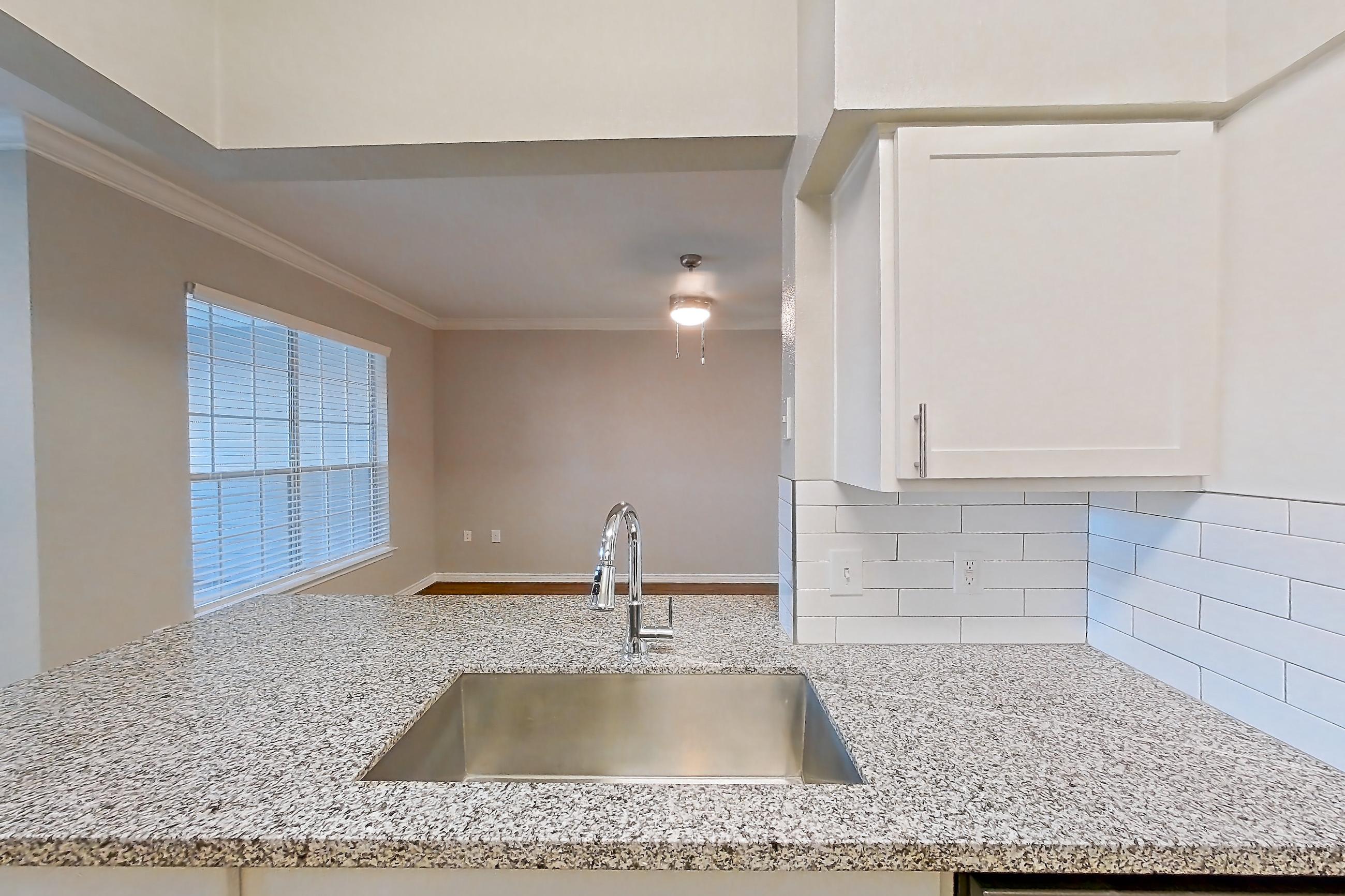 Kitchen with dark wood-finish flooring, dishwasher, electric range, light countertops, light stone countertops, light wood-finish flooring, oven/range, refrigerator, and stainless steel appliances, Apartment 0914 at Reserve at Kingwood