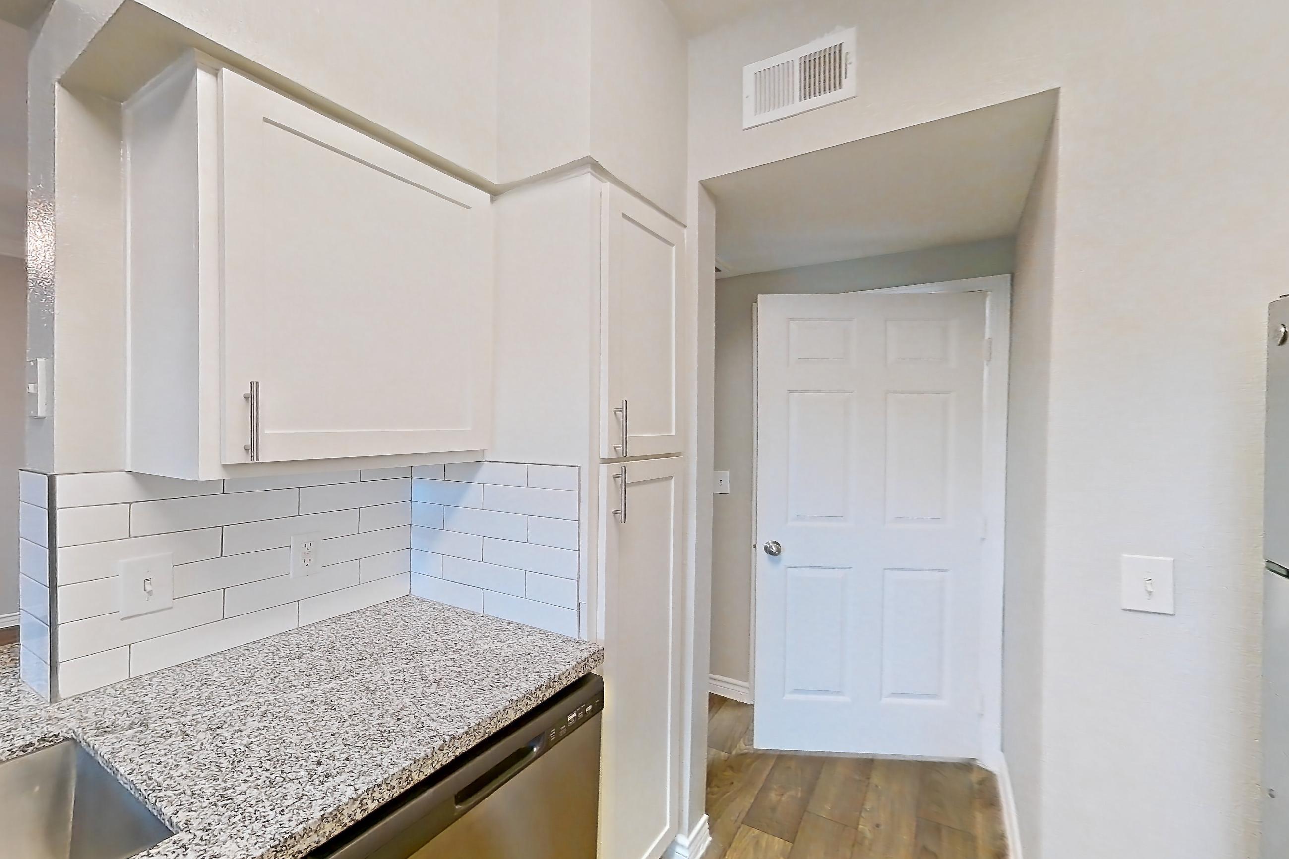 Kitchen with dark wood-finish flooring, dishwasher, electric range, light countertops, light stone countertops, light wood-finish flooring, oven/range, refrigerator, and stainless steel appliances, Apartment 0914 at Reserve at Kingwood