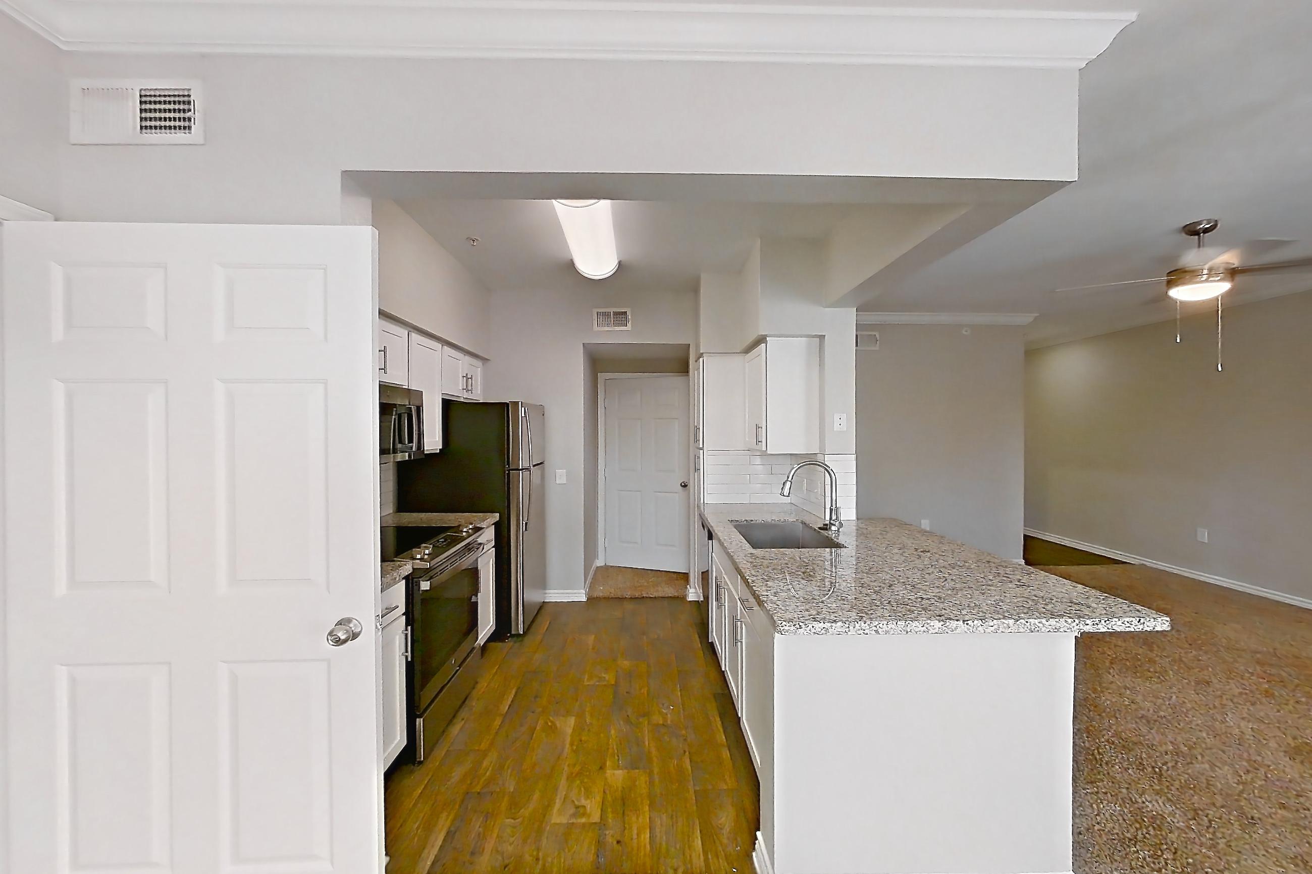 Dining room with dark carpet, dark wood-finish flooring, electric range, light stone countertops, oven/range, refrigerator, and stainless steel appliances, Apartment 1230 at Reserve at Kingwood