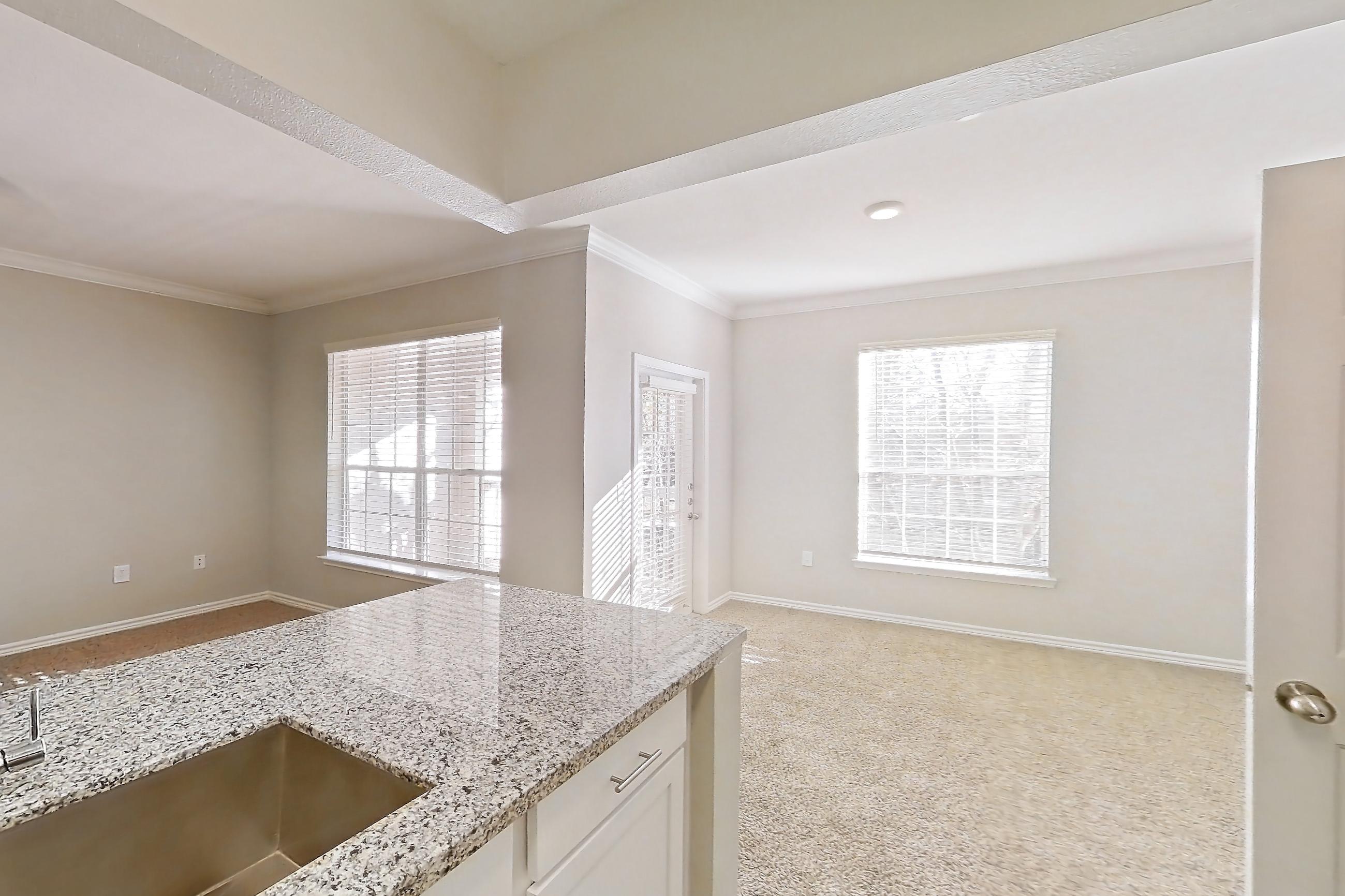Kitchen with dark carpet, dark wood-finish flooring, dishwasher, electric range, light stone countertops, oven/range, refrigerator, and stainless steel appliances, Apartment 1230 at Reserve at Kingwood