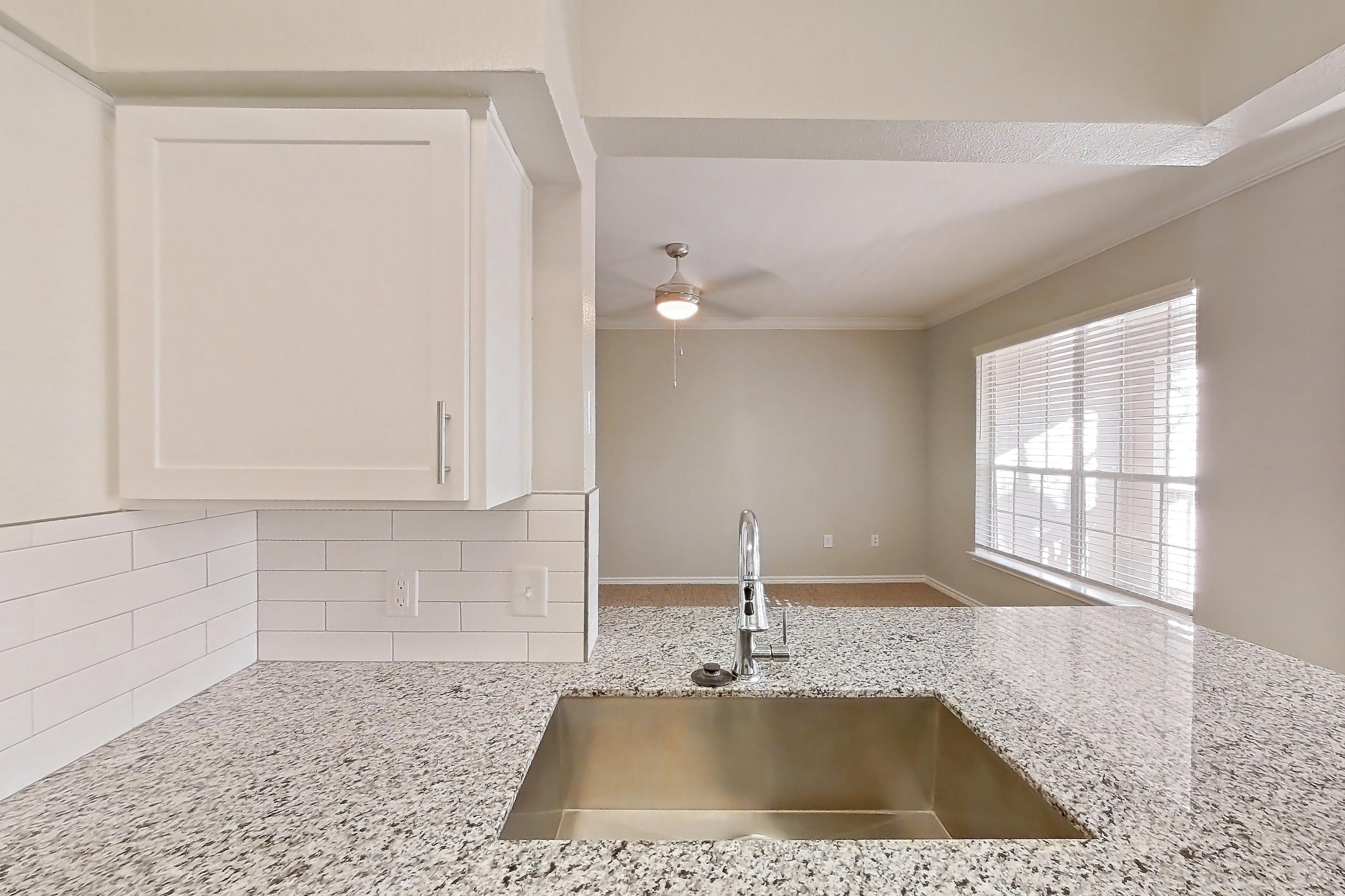 Kitchen with dark carpet, dark wood-finish flooring, dishwasher, electric range, light stone countertops, oven/range, refrigerator, and stainless steel appliances, Apartment 1230 at Reserve at Kingwood
