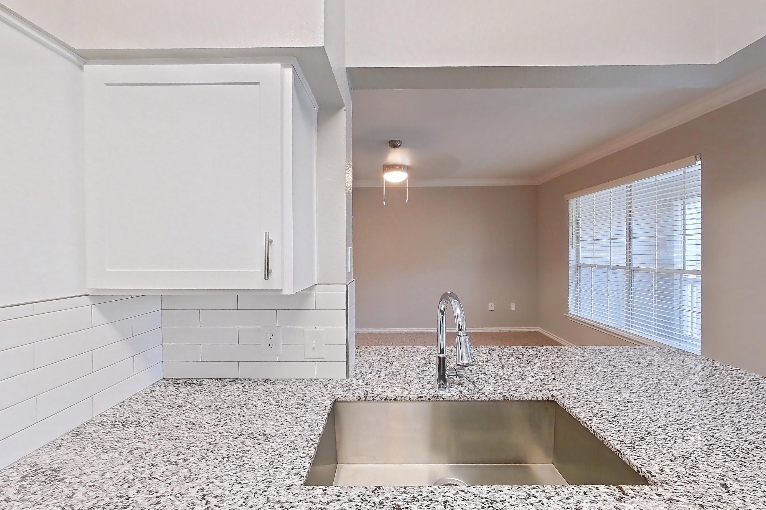 Kitchen with dark carpet, dark wood-finish flooring, dishwasher, electric range, light stone countertops, oven/range, refrigerator, and stainless steel appliances, Apartment 0435 at Reserve at Kingwood