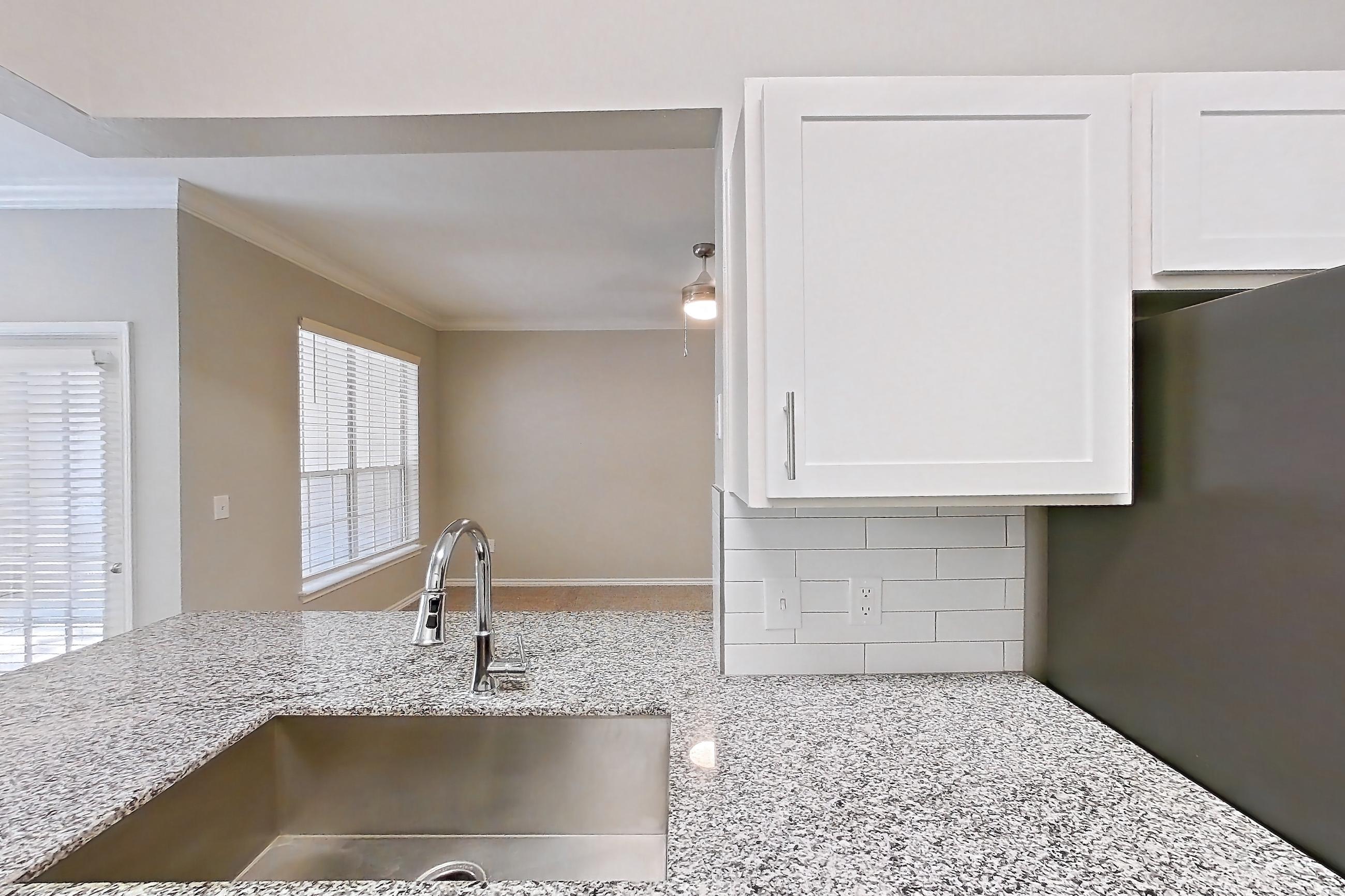 Kitchen with dark carpet, dark wood-finish flooring, dishwasher, electric range, light countertops, light stone countertops, microwave, oven/range, refrigerator, stainless steel appliances, and white appliances, Apartment 0529 at Reserve at Kingwood