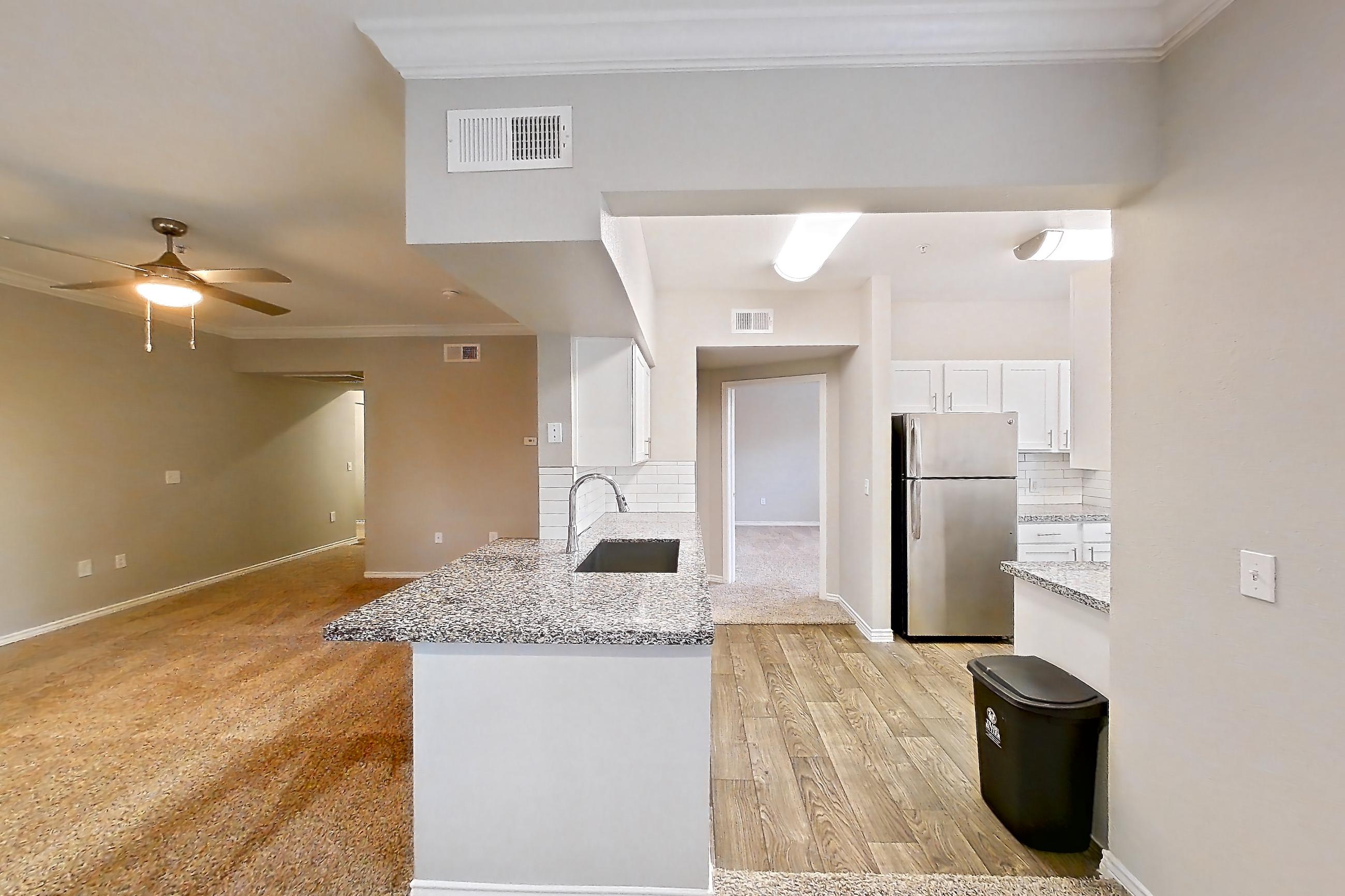 Dining room with light carpet, light stone countertops, light wood-finish flooring, refrigerator, and stainless steel appliances, Apartment 1031 at Reserve at Kingwood