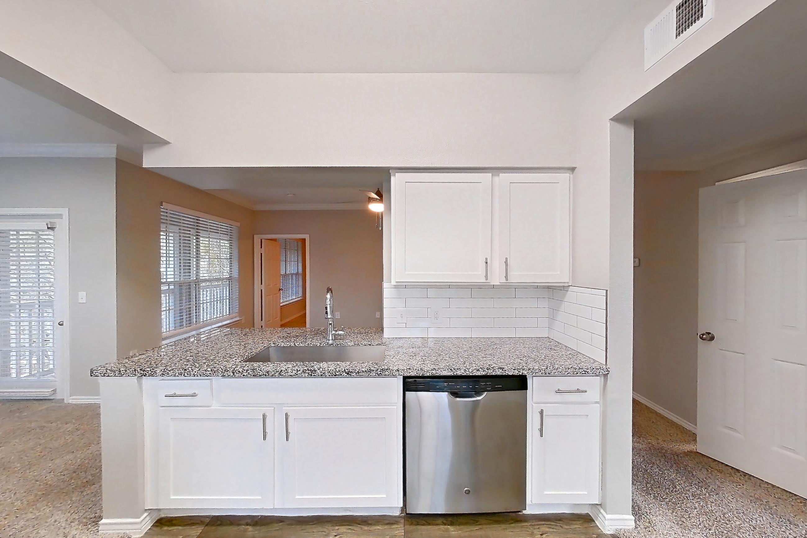 Kitchen with dishwasher, electric range, light carpet, light countertops, light stone countertops, light wood-finish flooring, microwave, oven/range, refrigerator, and stainless steel appliances, Apartment 1031 at Reserve at Kingwood