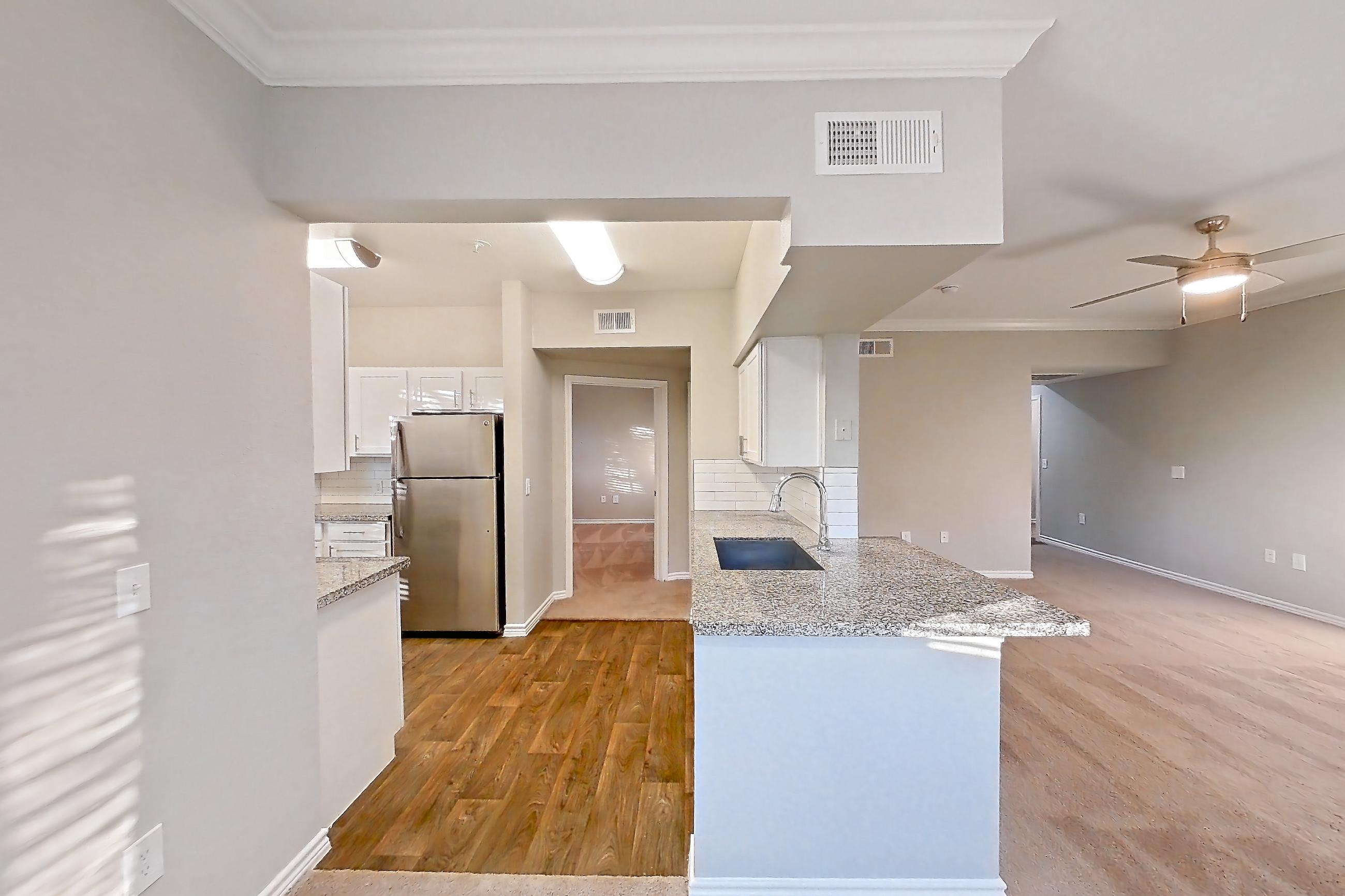 Dining room with dark carpet, light carpet, light stone countertops, light wood-finish flooring, refrigerator, and stainless steel appliances, Apartment 0828 at Reserve at Kingwood