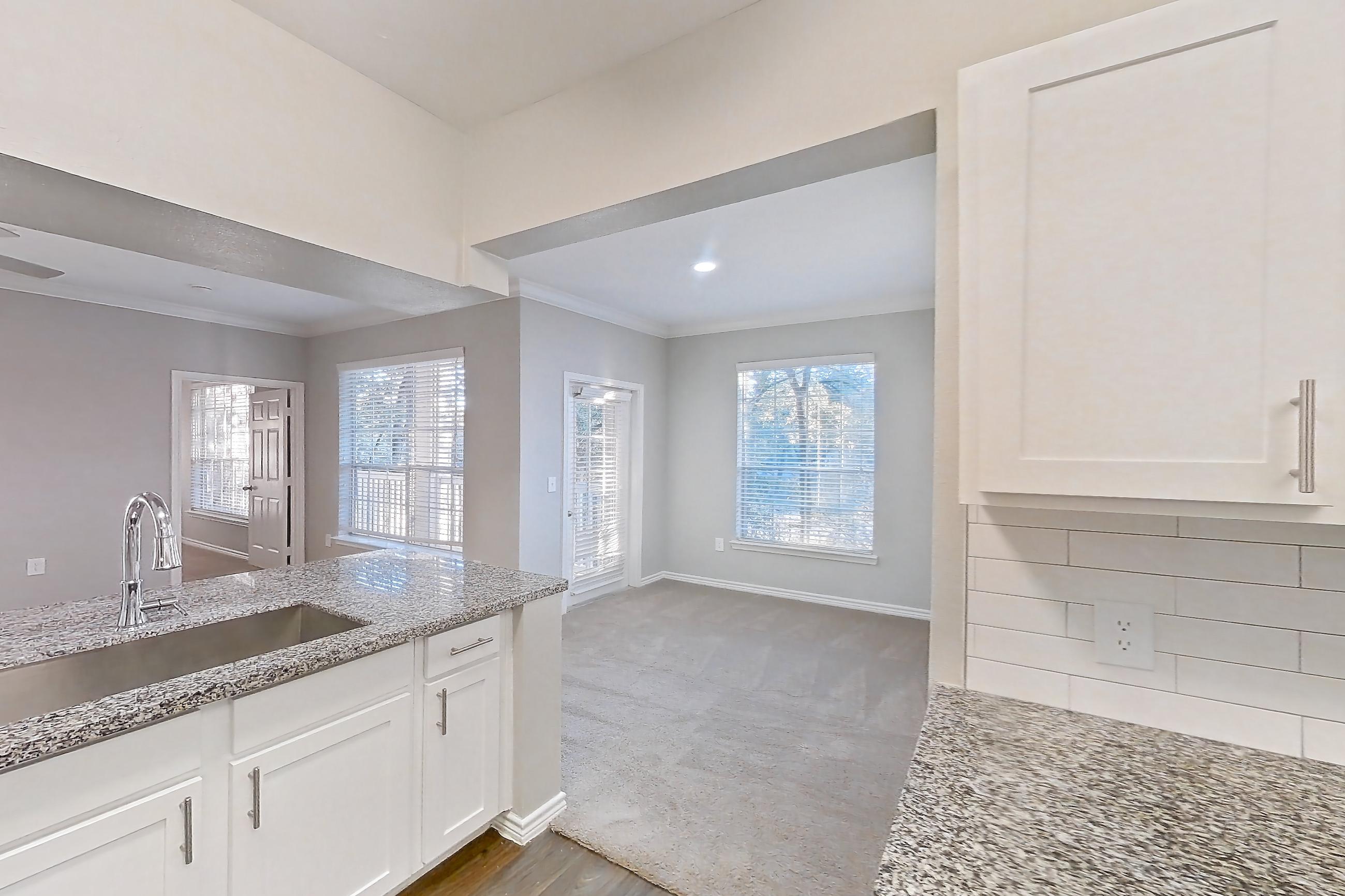 Kitchen with dark carpet, dark wood-finish flooring, dishwasher, electric range, light stone countertops, oven/range, refrigerator, and stainless steel appliances, Apartment 0828 at Reserve at Kingwood