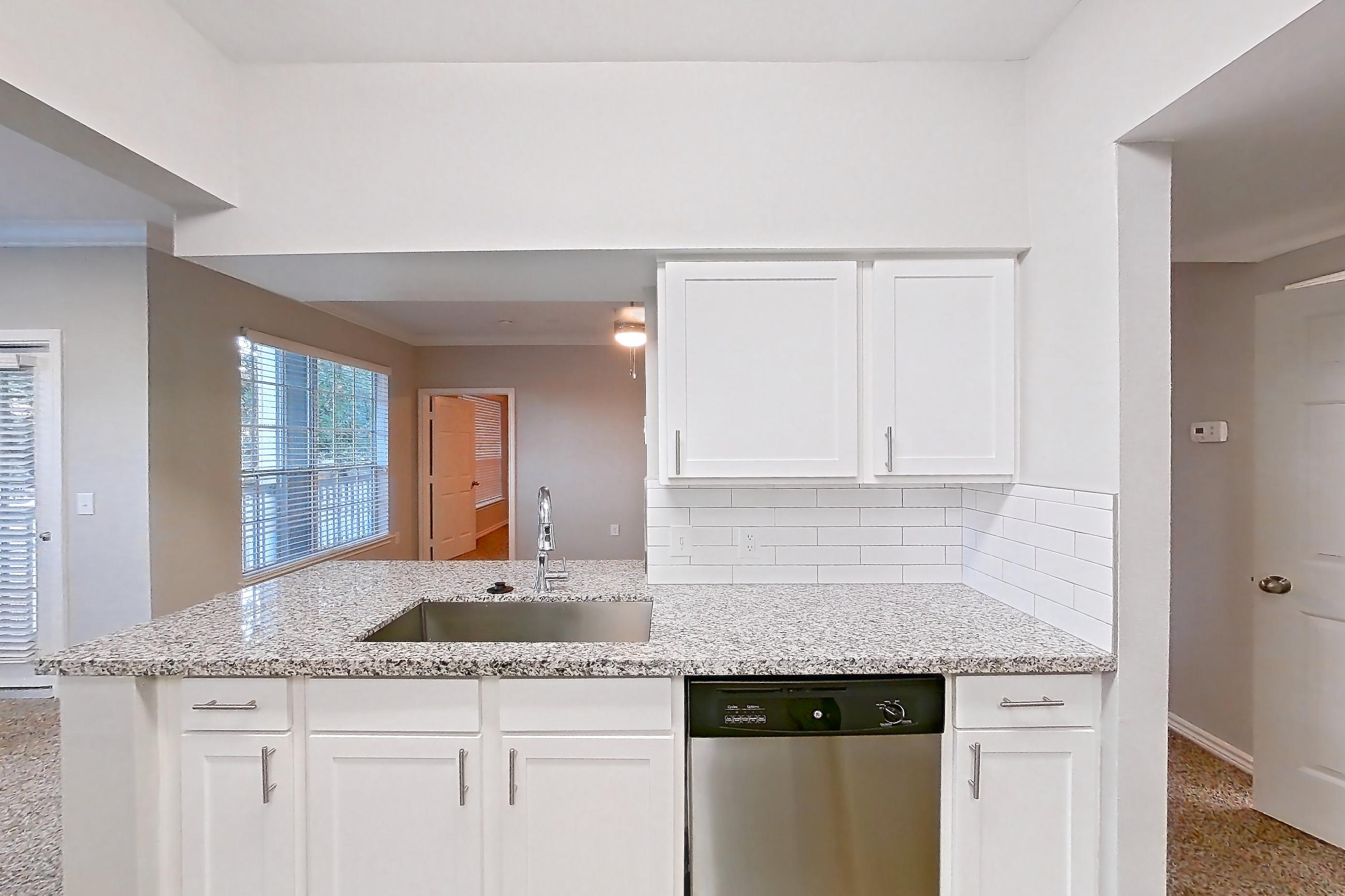 Kitchen with dark carpet, dark wood-finish flooring, dishwasher, electric range, light carpet, light stone countertops, light wood-finish flooring, oven/range, refrigerator, and stainless steel appliances, Apartment 0825 at Reserve at Kingwood