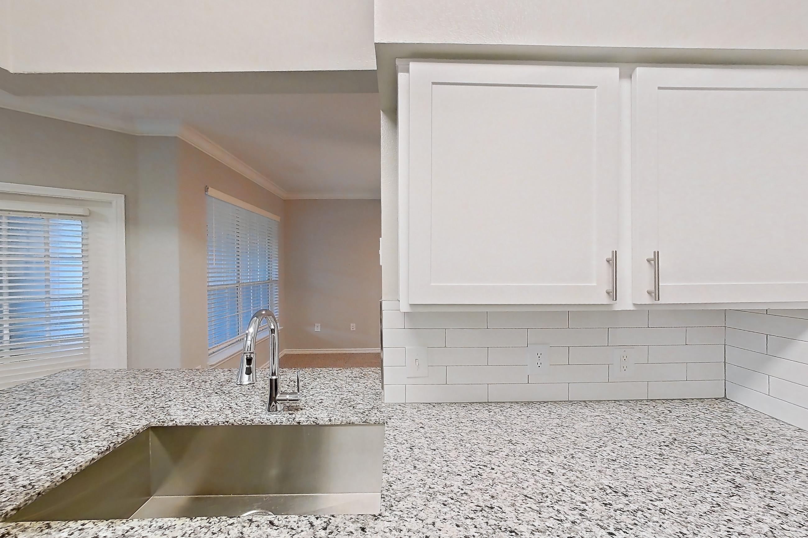 Kitchen with dark carpet, dark wood-finish flooring, dishwasher, electric range, light countertops, light stone countertops, oven/range, refrigerator, and stainless steel appliances, Apartment 1122 at Reserve at Kingwood