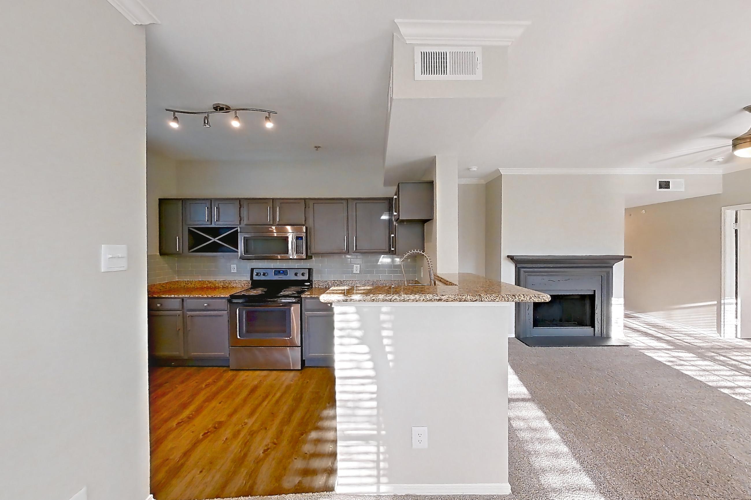 Dining room with dark carpet, electric range, fireplace, light countertops, oven/range, and stainless steel appliances, Apartment 0327 at Marquis Champions Forest