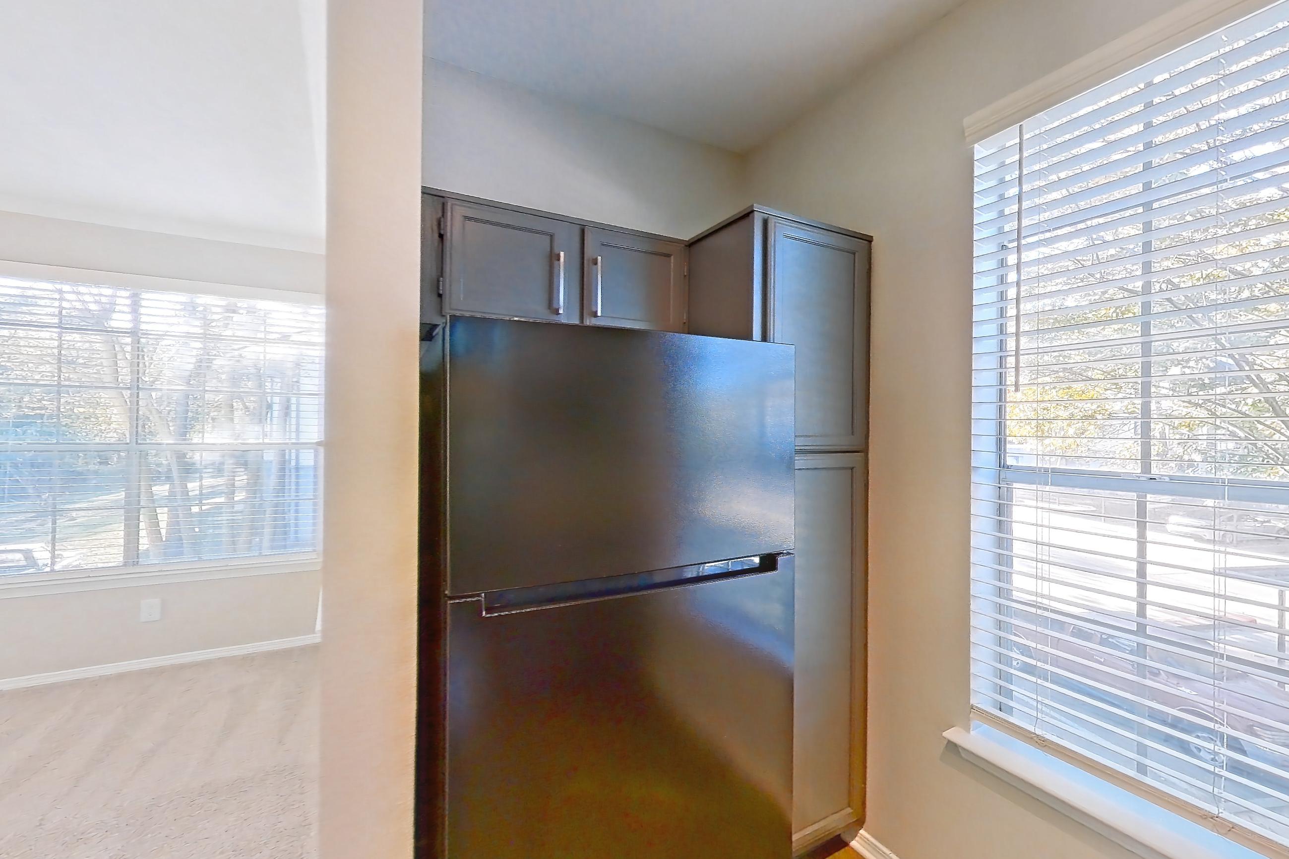 Kitchen with dark countertops, dishwasher, electric range, light carpet, light countertops, light stone countertops, light wood-finish flooring, microwave, oven/range, refrigerator, and stainless steel appliances, Apartment 0327 at Marquis Champions Forest