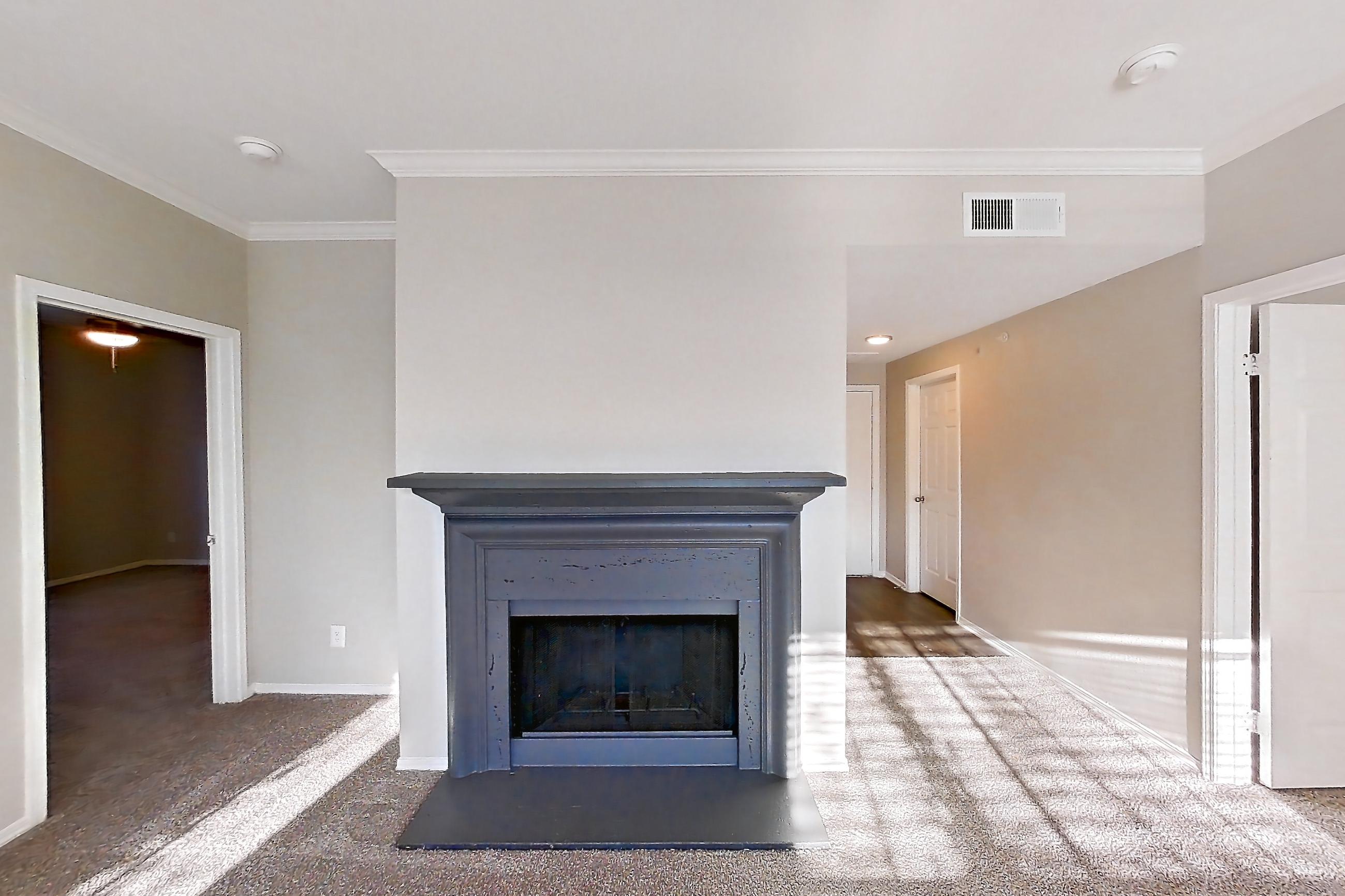 Living room with fireplace and light carpet, Apartment 0327 at Marquis Champions Forest