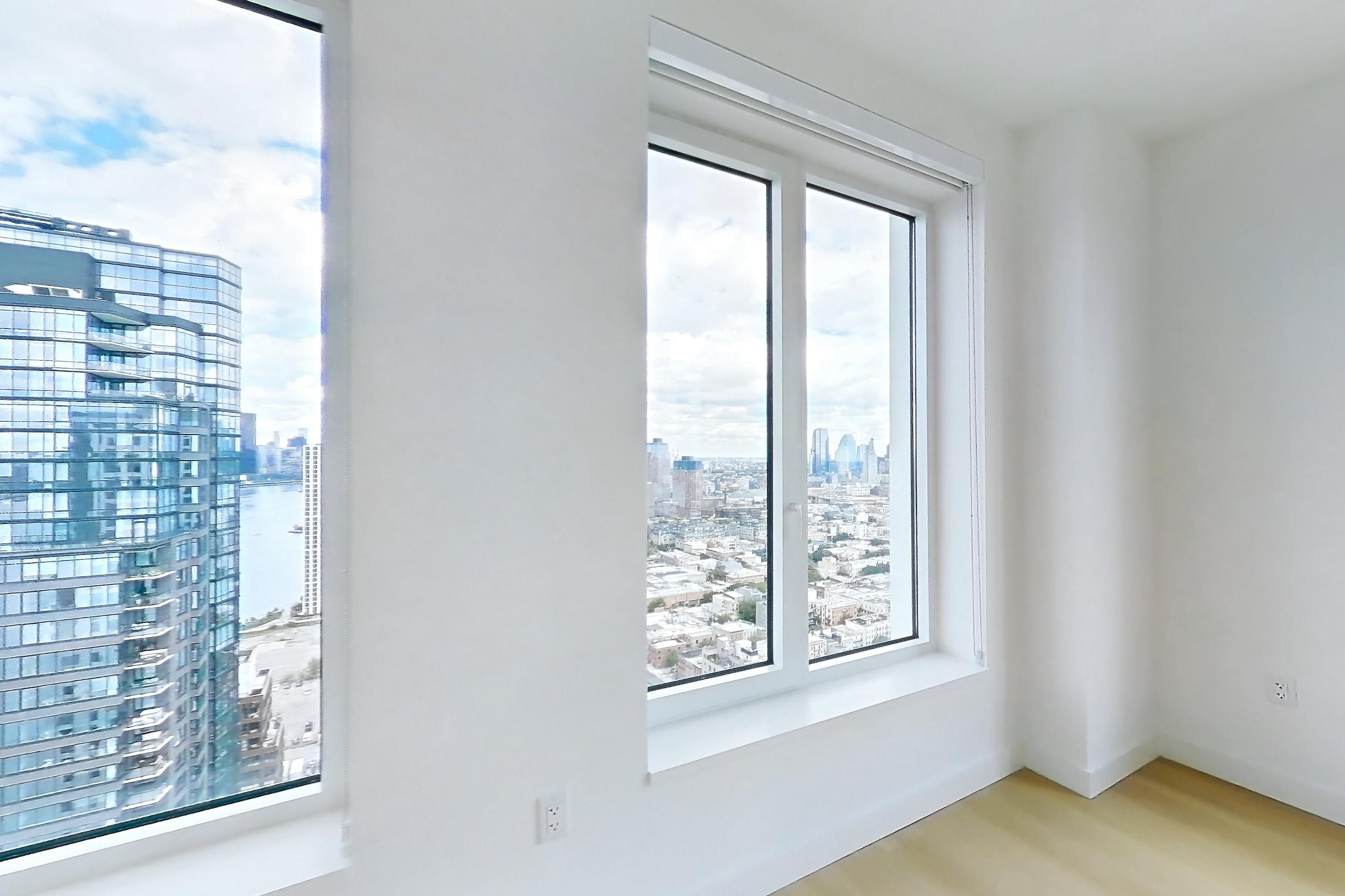 Living room with city view and light wood-finish flooring, Apartment 3411S at The Riverie