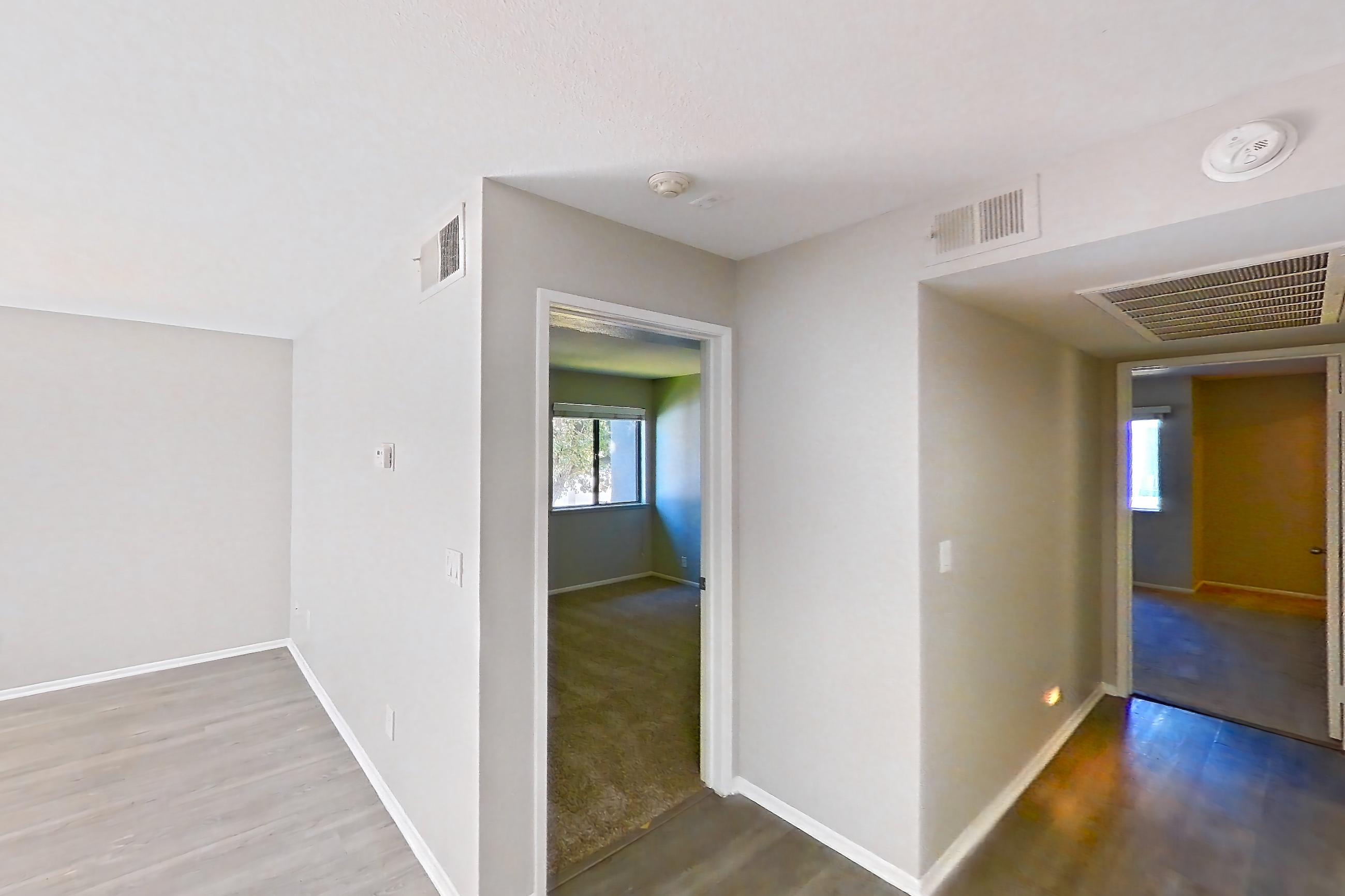 Dining room with dark carpet, dark wood-finish flooring, electric range, in-unit laundry, light countertops, light stone countertops, light wood-finish flooring, oven/range, range hood, refrigerator, stainless steel appliances, and white appliances, Apartment Z-05 at Avana Rancho Cucamonga