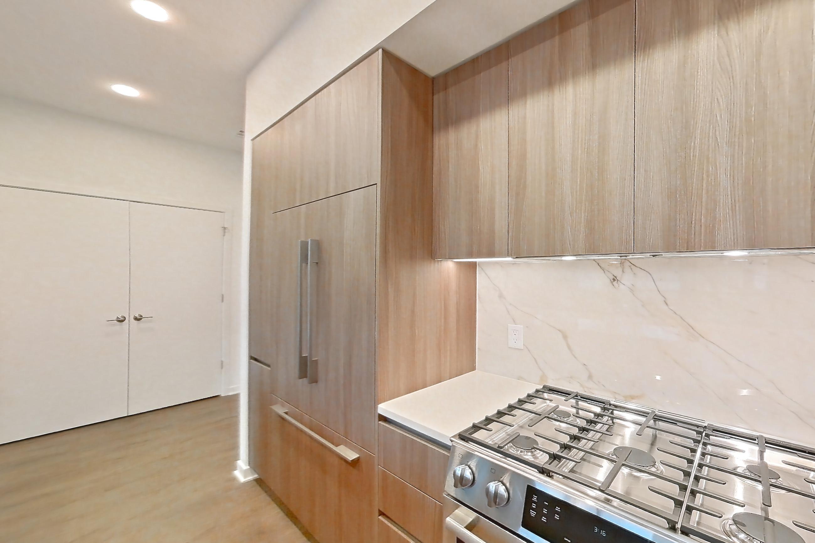 Kitchen with gas range, light stone countertops, light wood-finish flooring, oven/range, and stainless steel appliances, Apartment 0120 at Aerie
