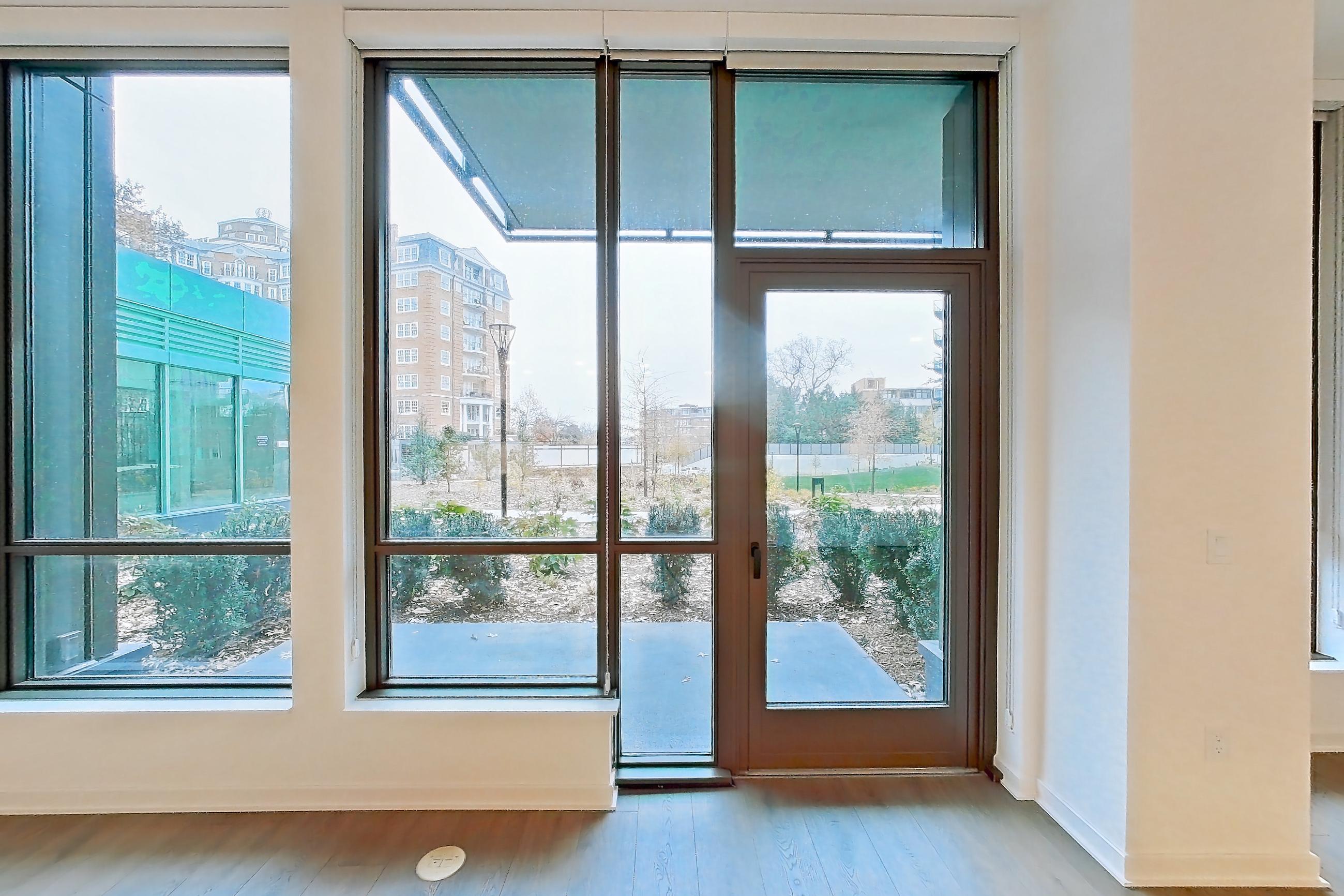 Living room with city view and light wood-finish flooring, Apartment 0120 at Aerie